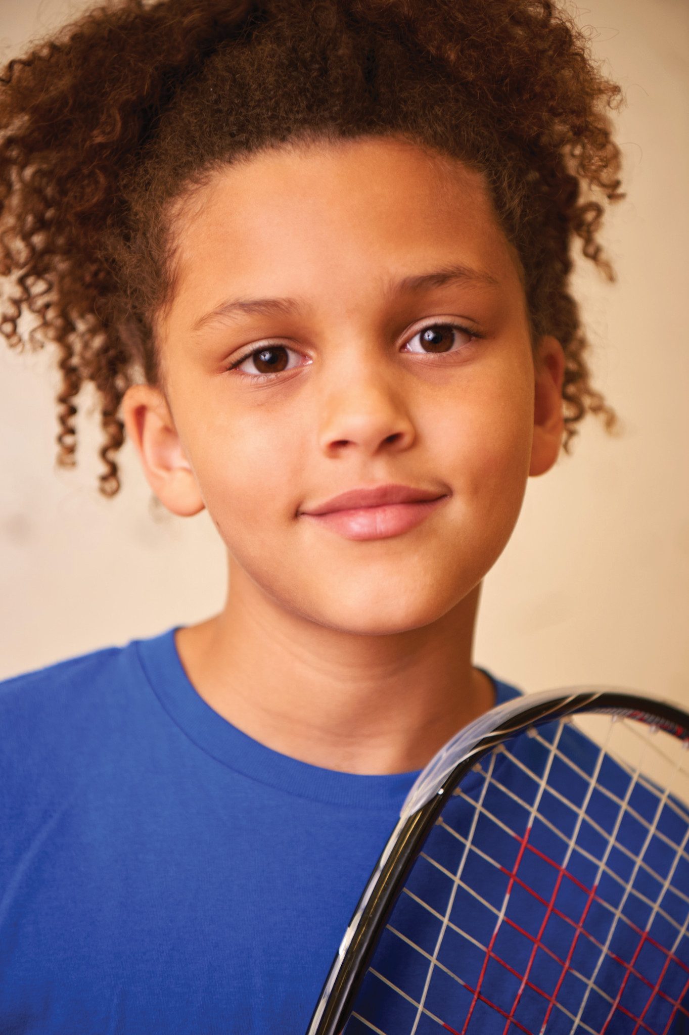 Close view of a child holding a racquetball racquet