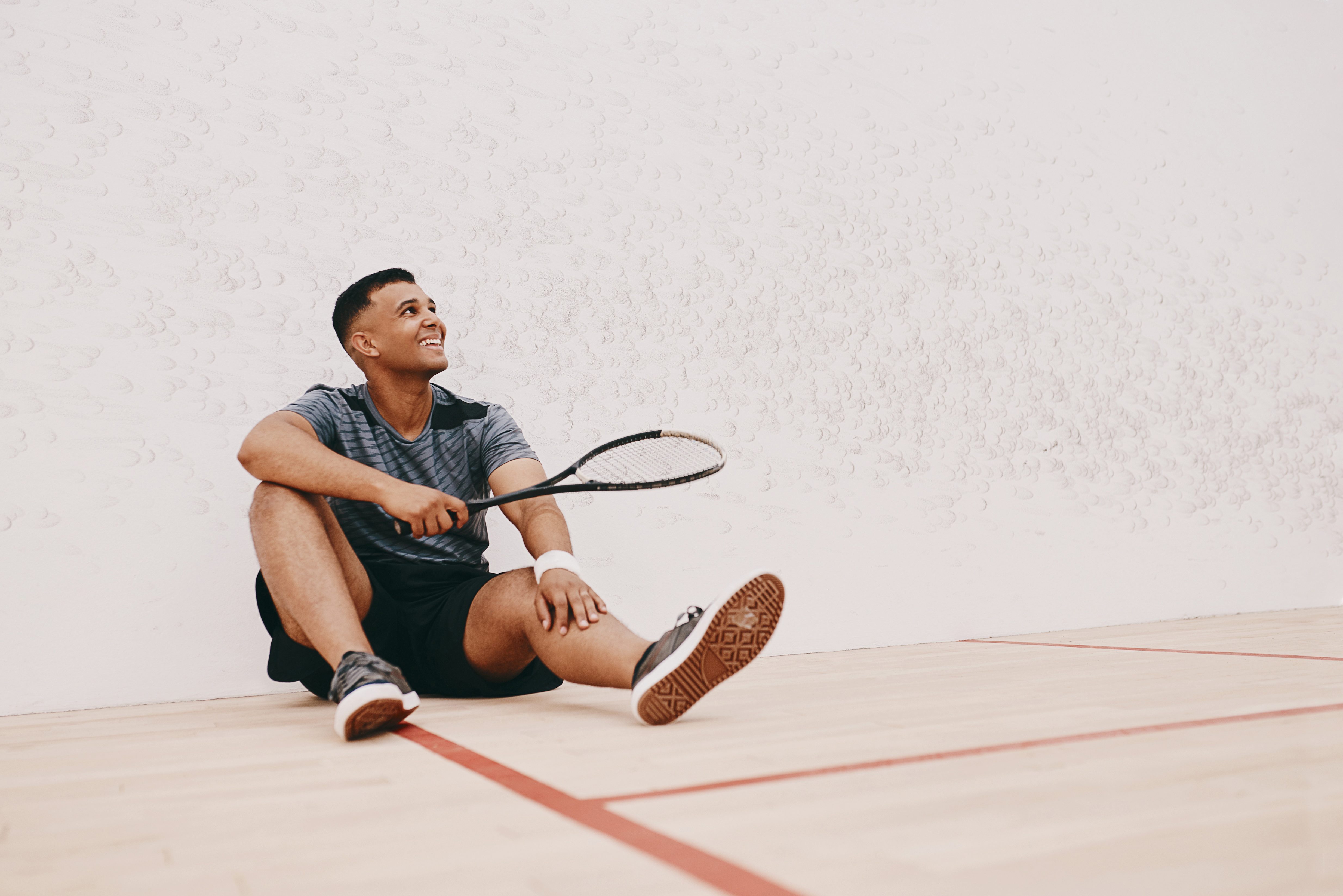 A young man taking a break after playing a game of squash