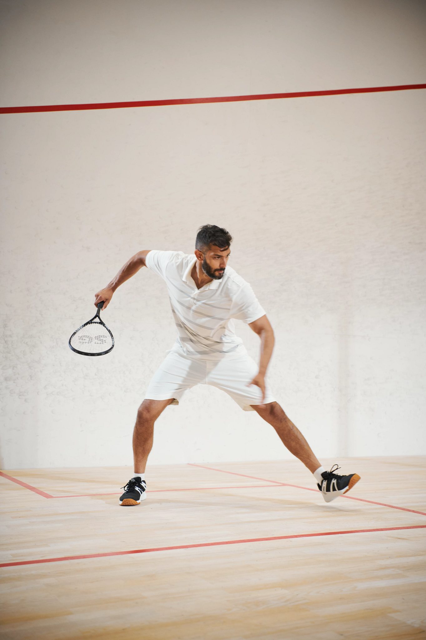 a man gets ready to take a swing while playing squash