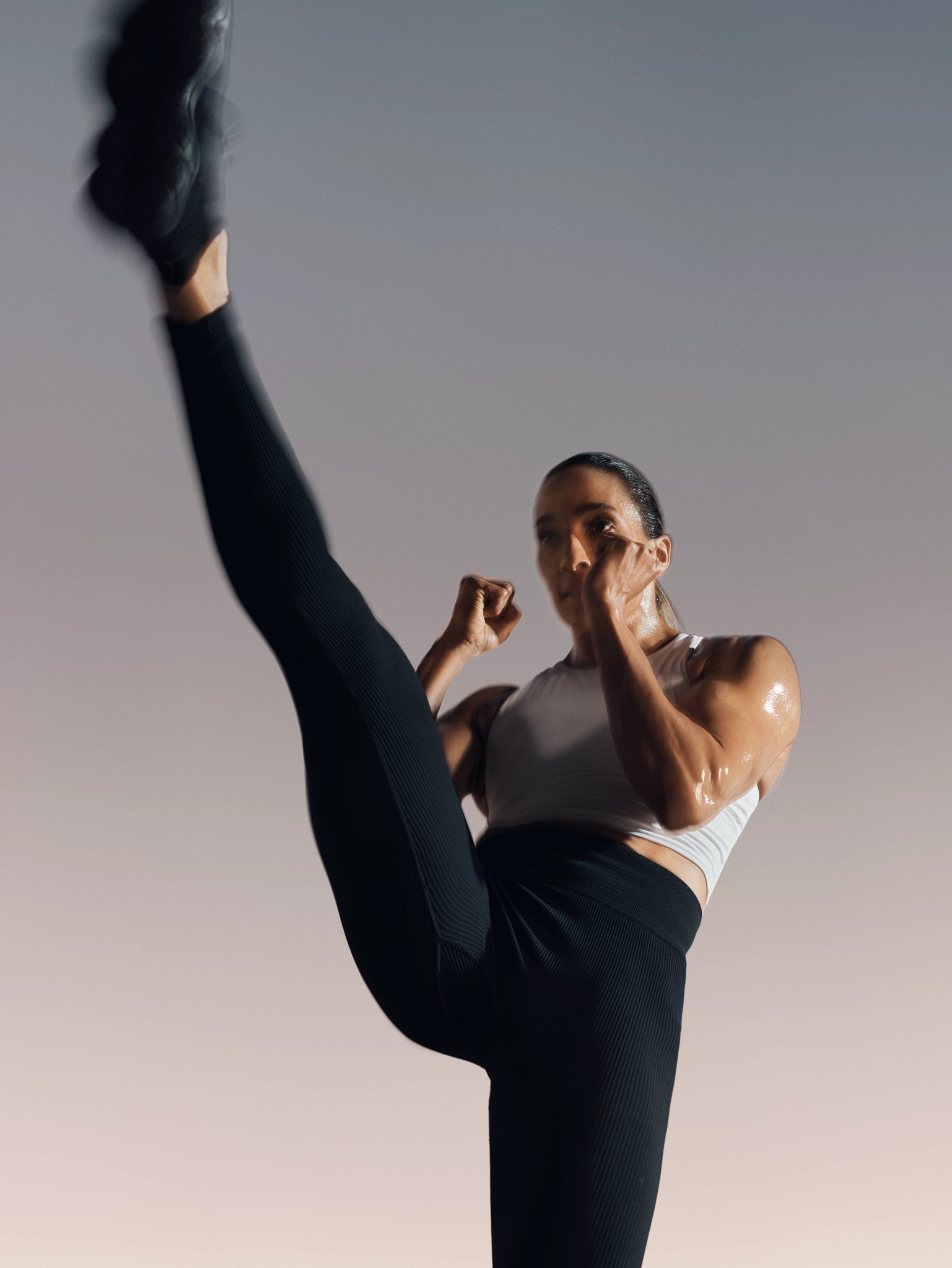 Strike kickboxing martial arts class participant in front kick position at Life Time