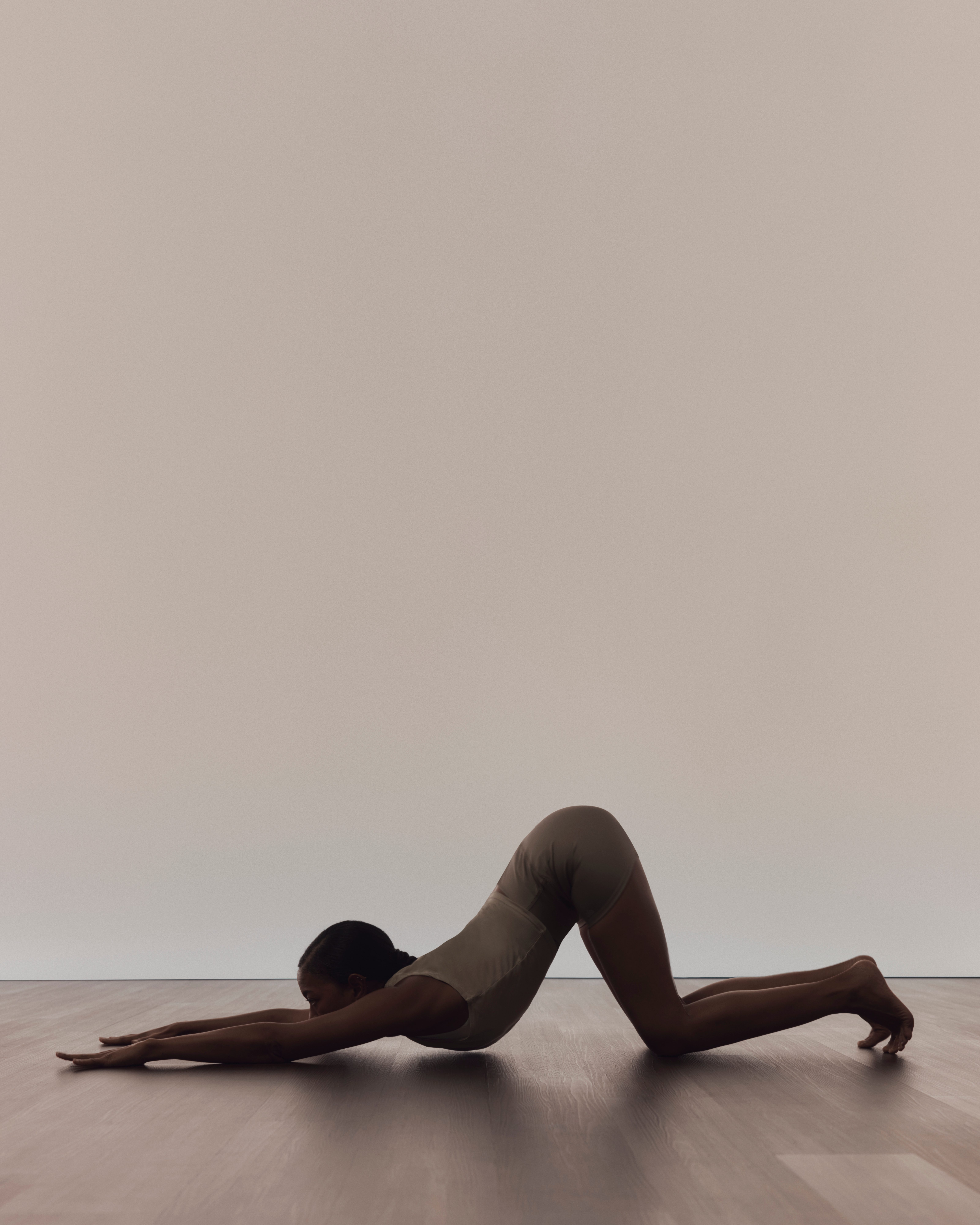 Profile of a person in puppy pose during a surrender yoga class