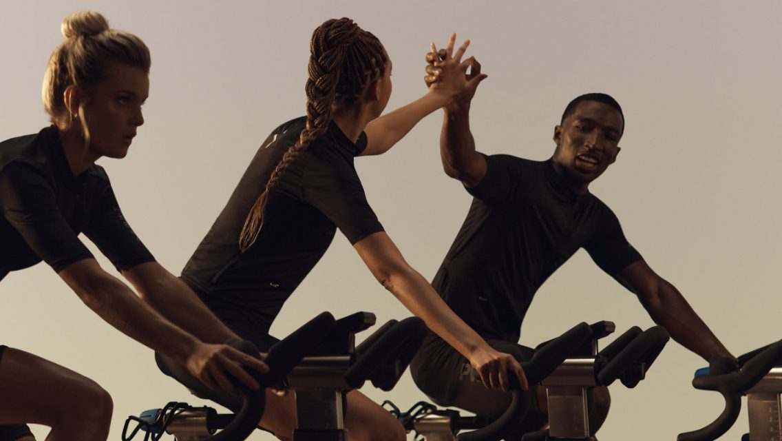 a group of people high fiving in a cycle class