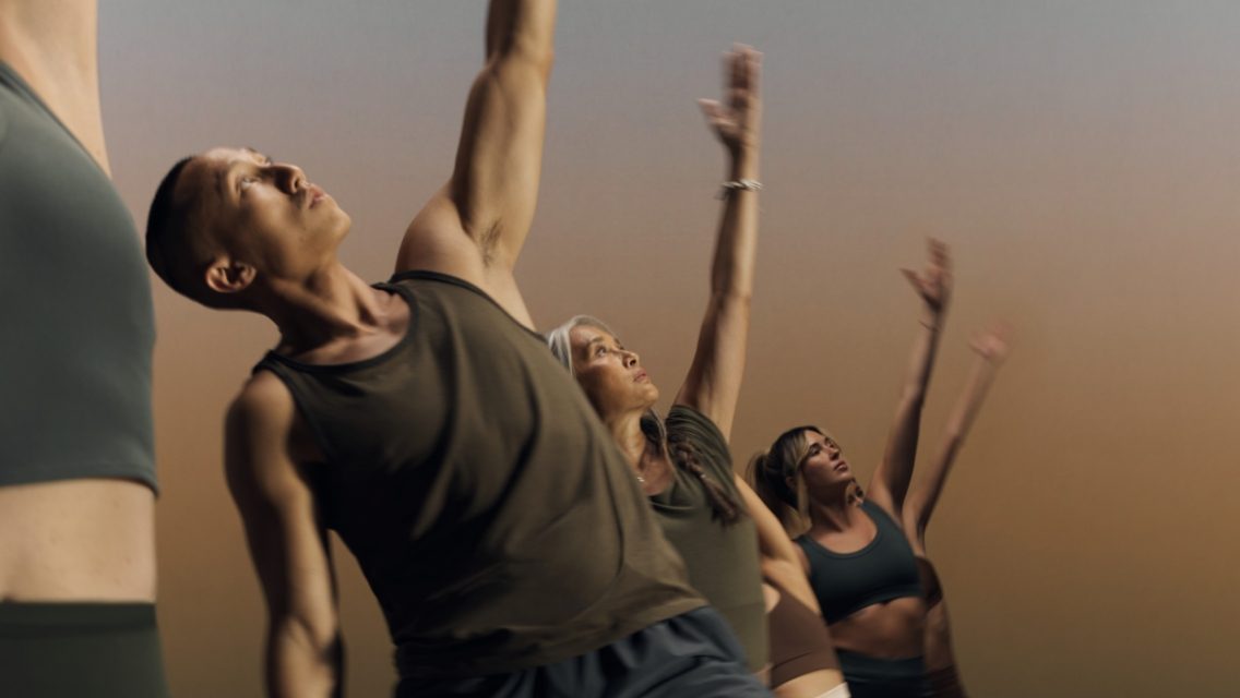 a group of men and woman working out in a yoga class