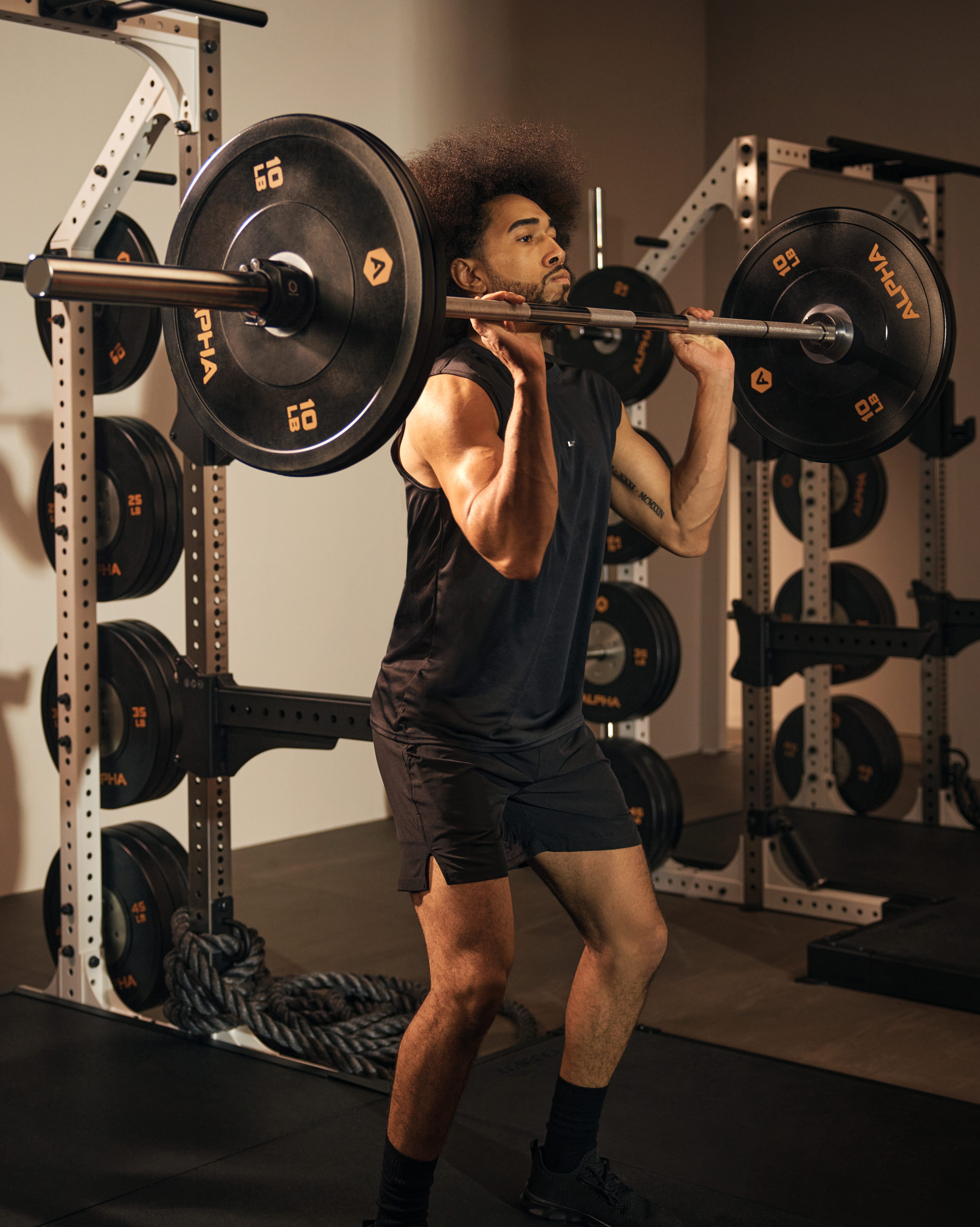 Alpha boutique group training class featuring a man lifting a barbell