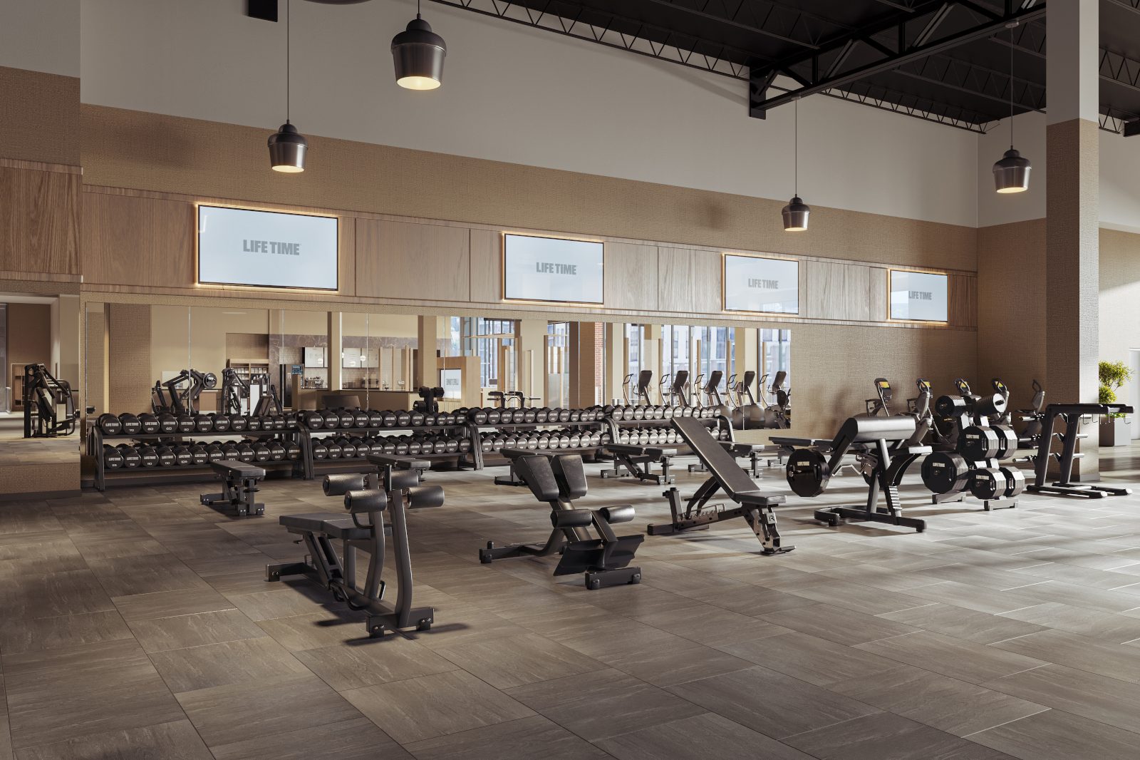 A clean and organized fitness floor with digital signage screens overhead showcasing a Life Time logo
