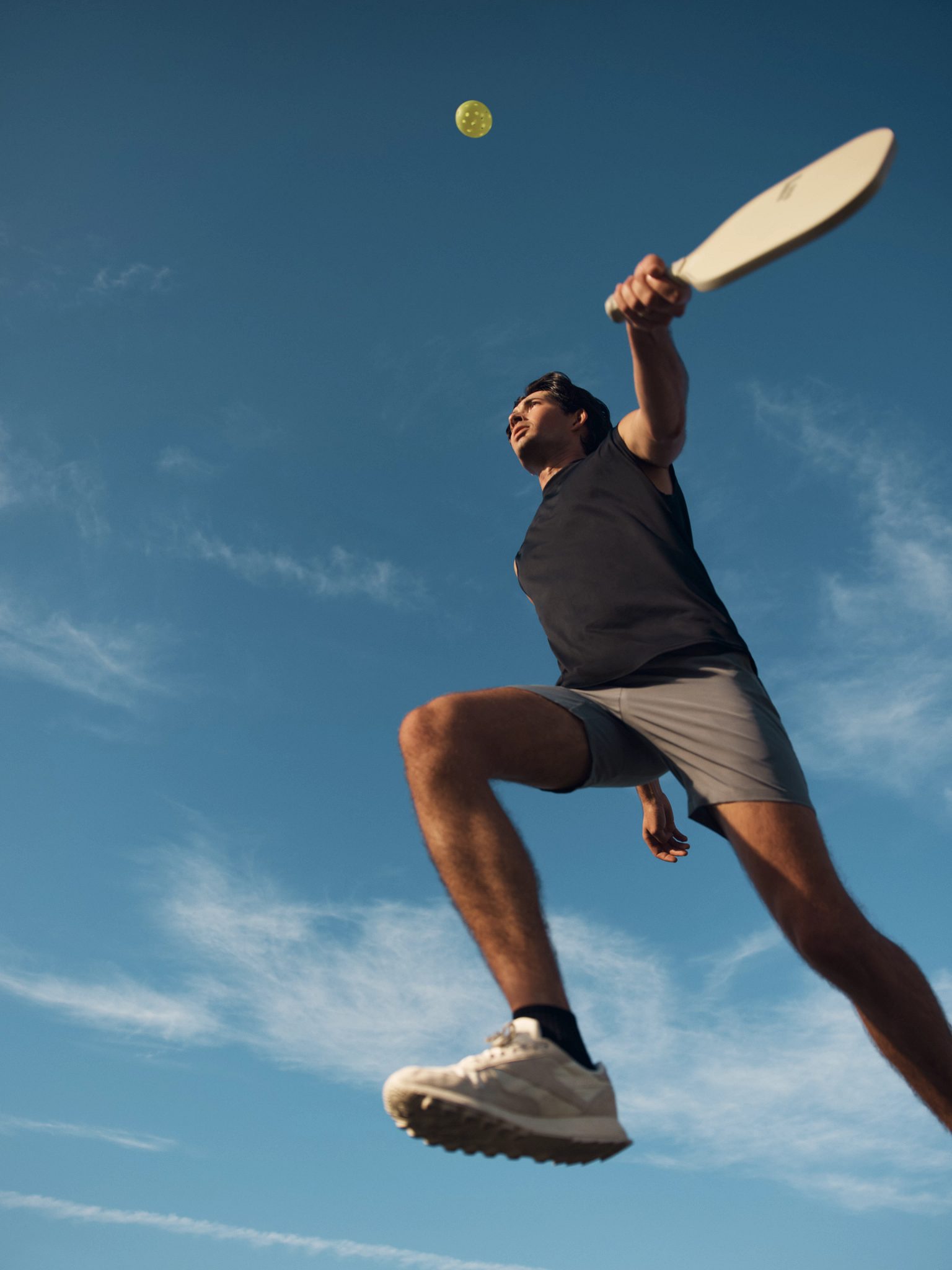 A pickleball player about to hit the ball