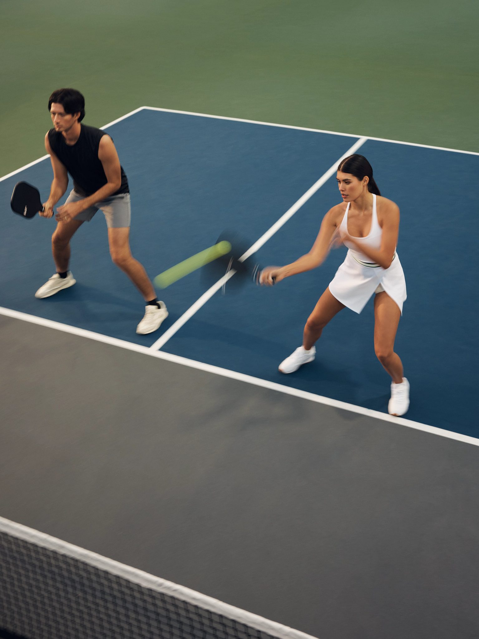 Action shot of a doubles pickleball match with one team at the kitchen