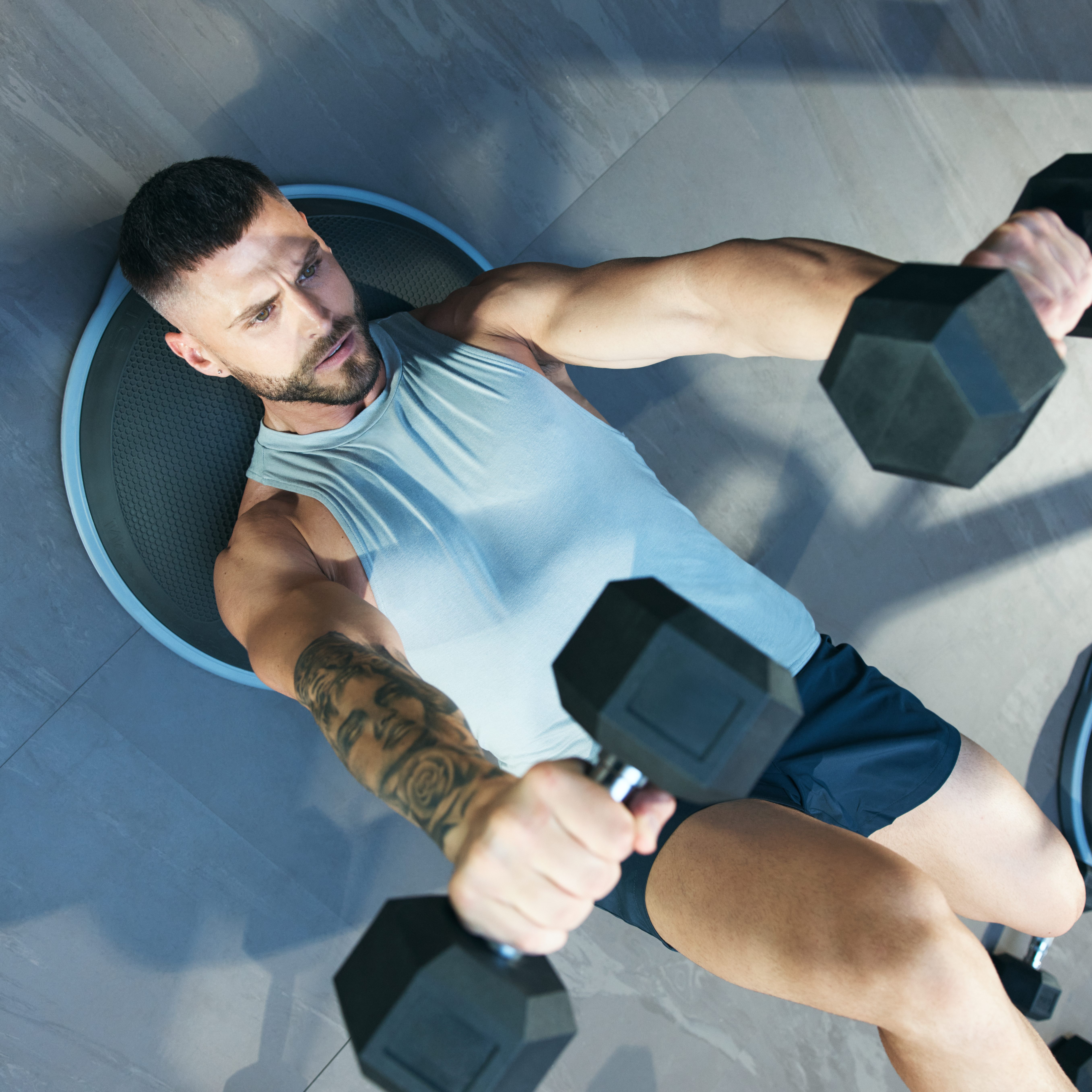 Man lifting dumbbells above his head in the UltraFit boutique group training class