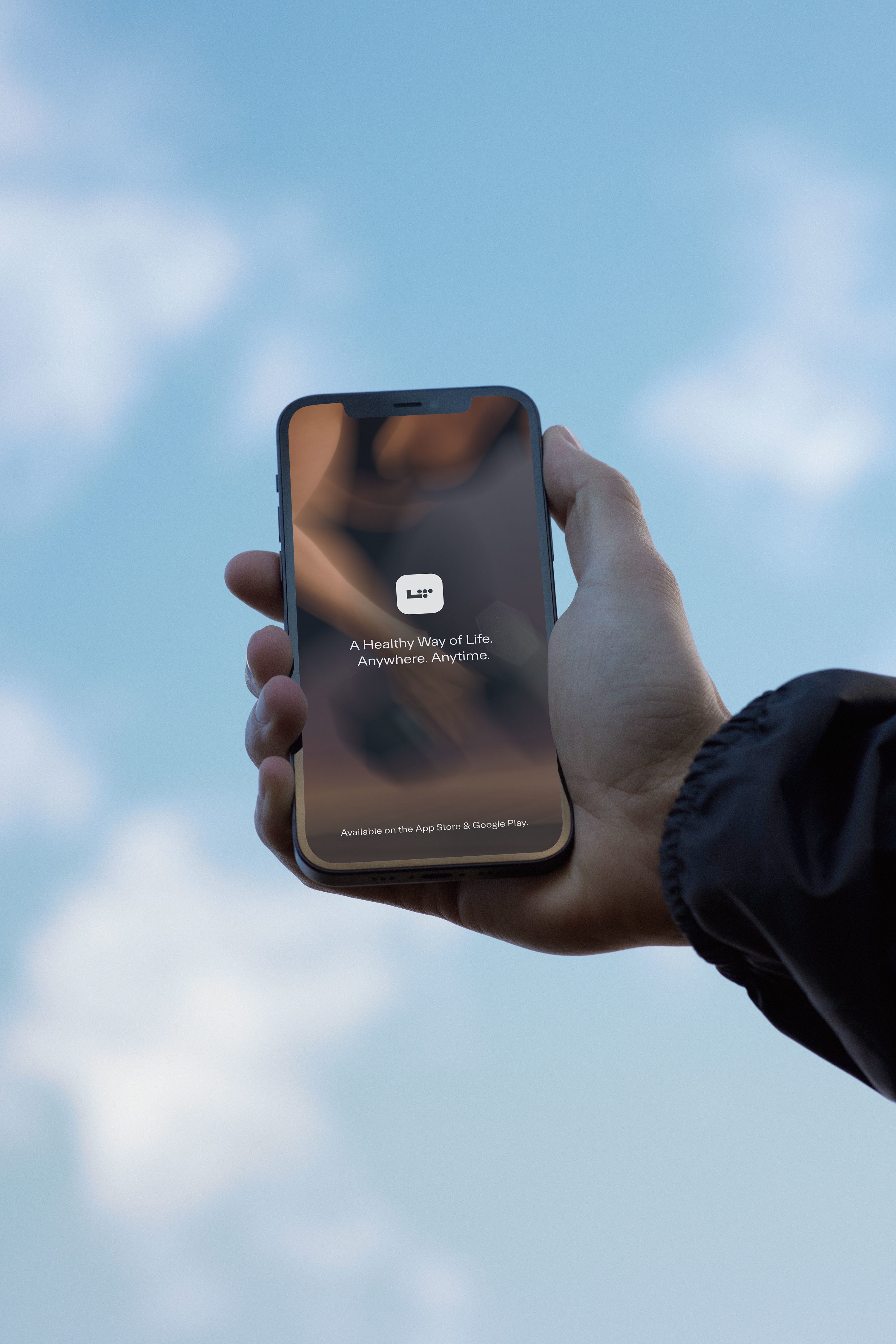 A hand holding a phone with a blue sky in the background