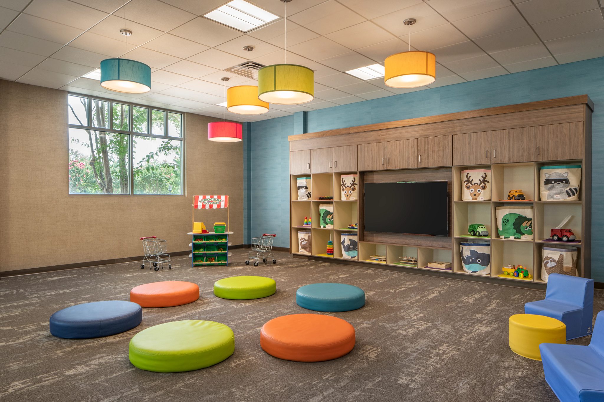 Toddler area with colorful seating pads and toys in a Life Time Child Center