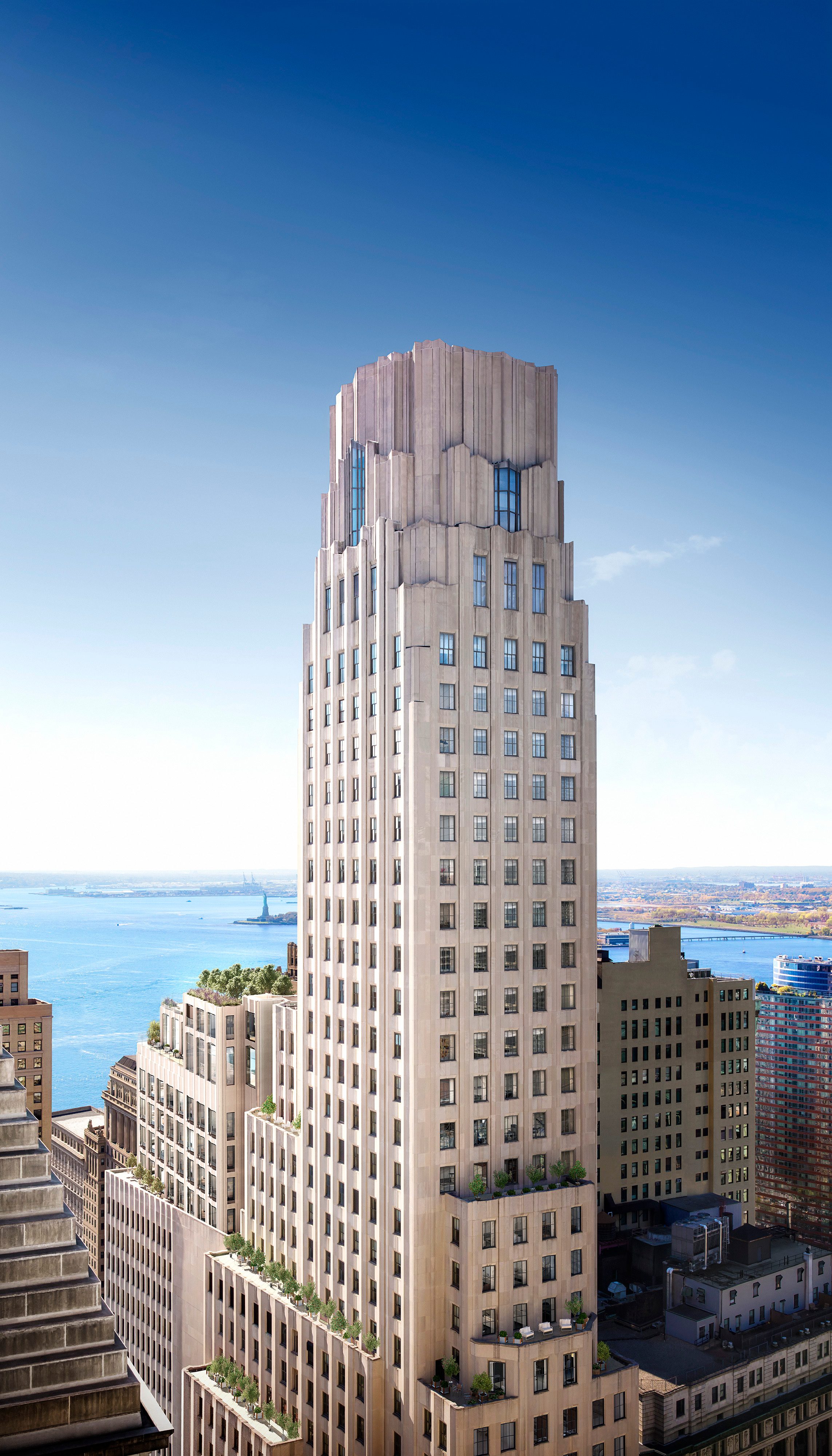 An aerial view of the top of the One Wall Street building, with the statue of liberty in the background