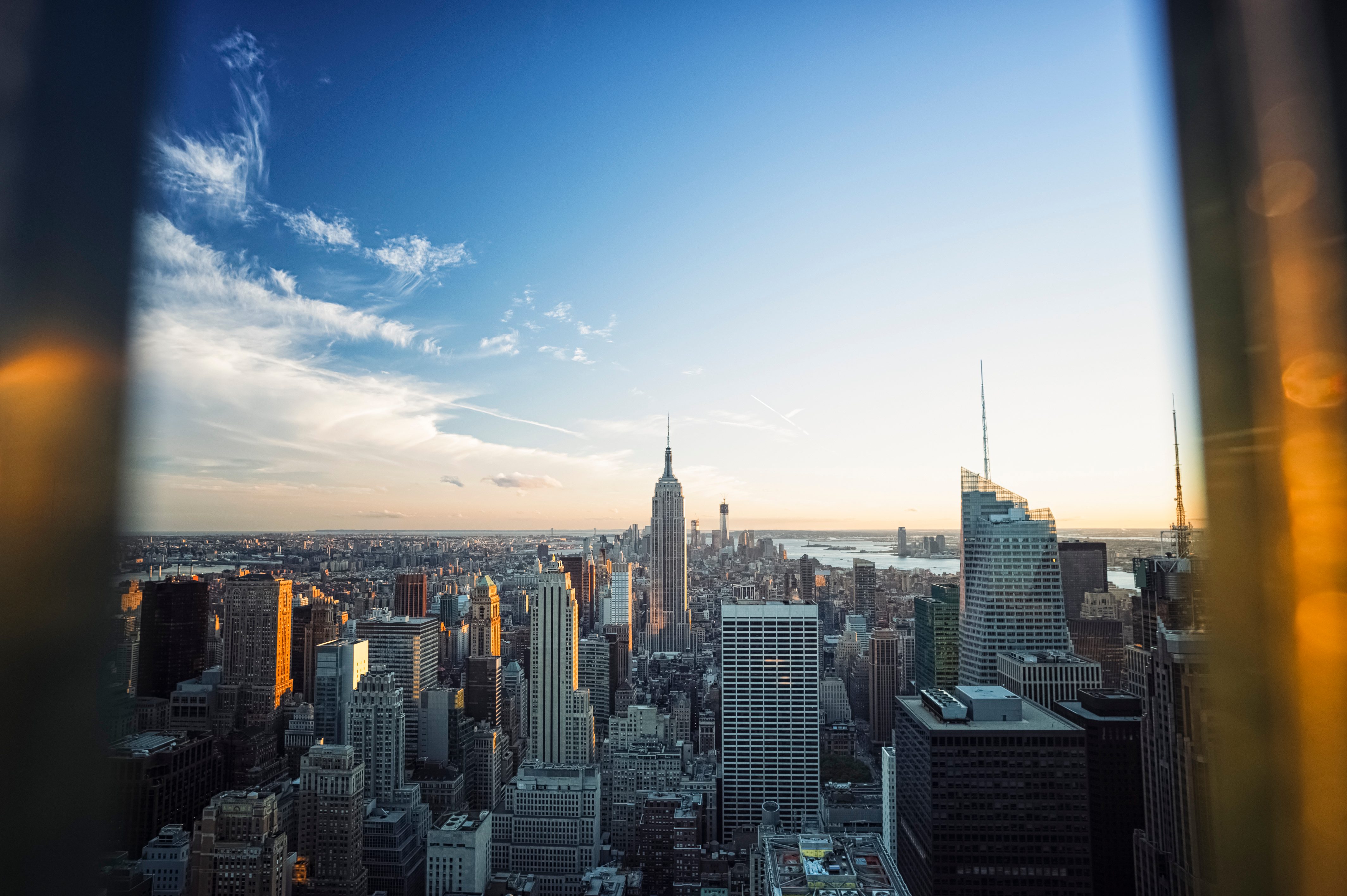 Manhattan skyline with Empire State Building taken from a window at sunset.