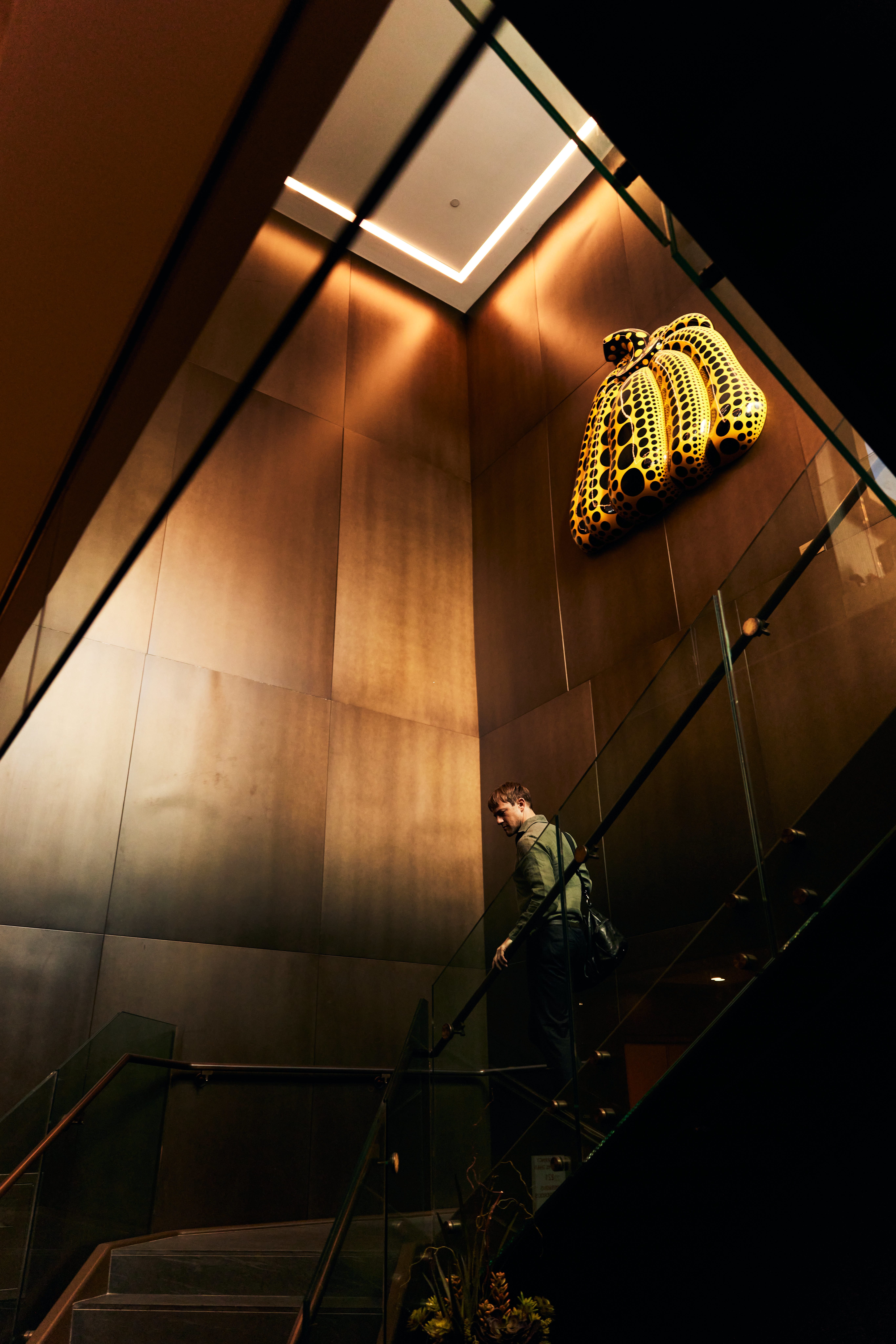 A man walking down a staircase while carrying a gym bag
