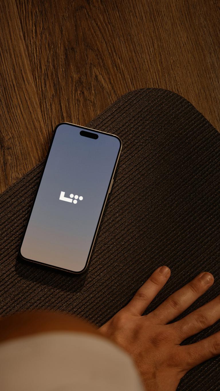 phone displaying L T app on a yoga mat
