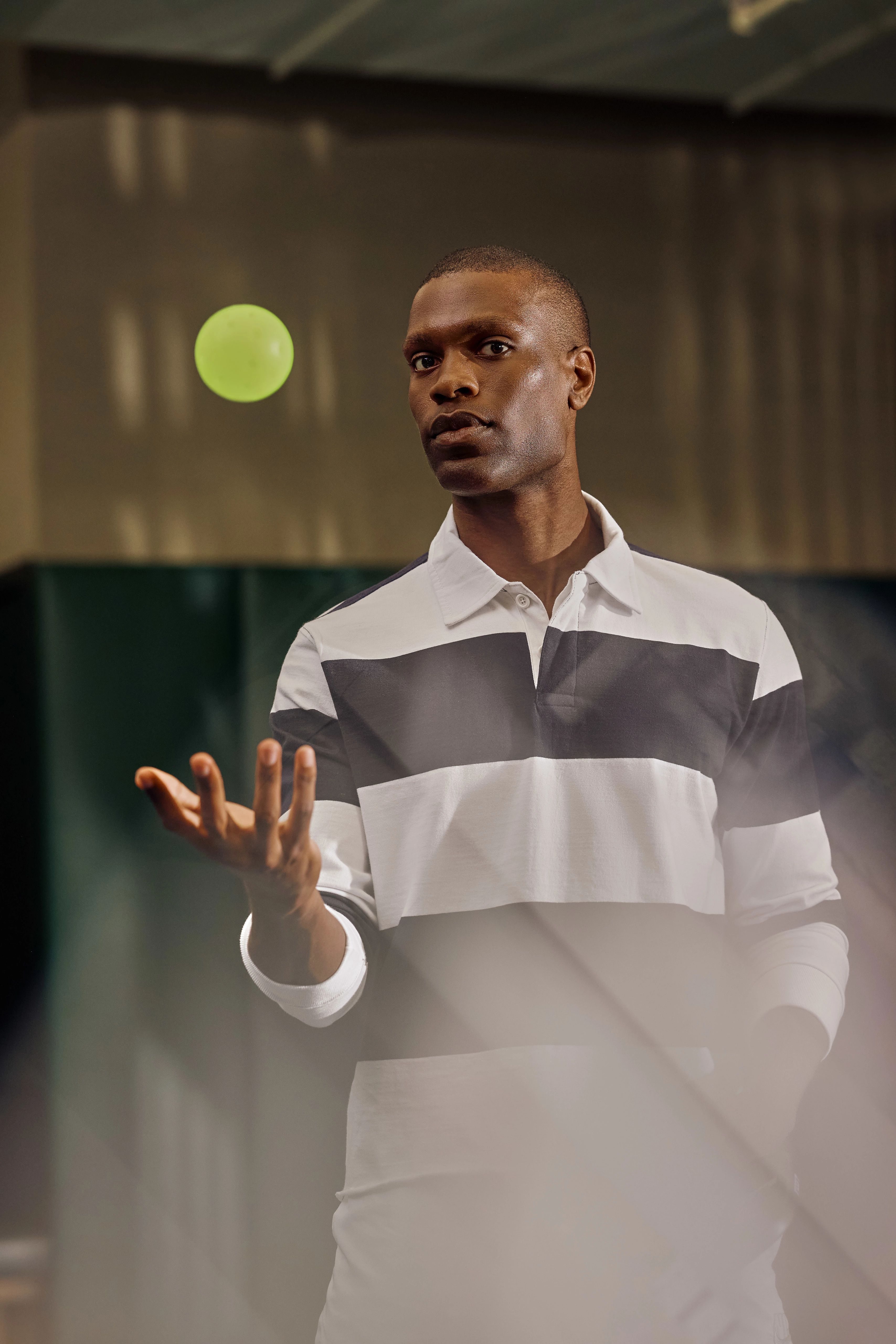 man throwing a pickleball in the air