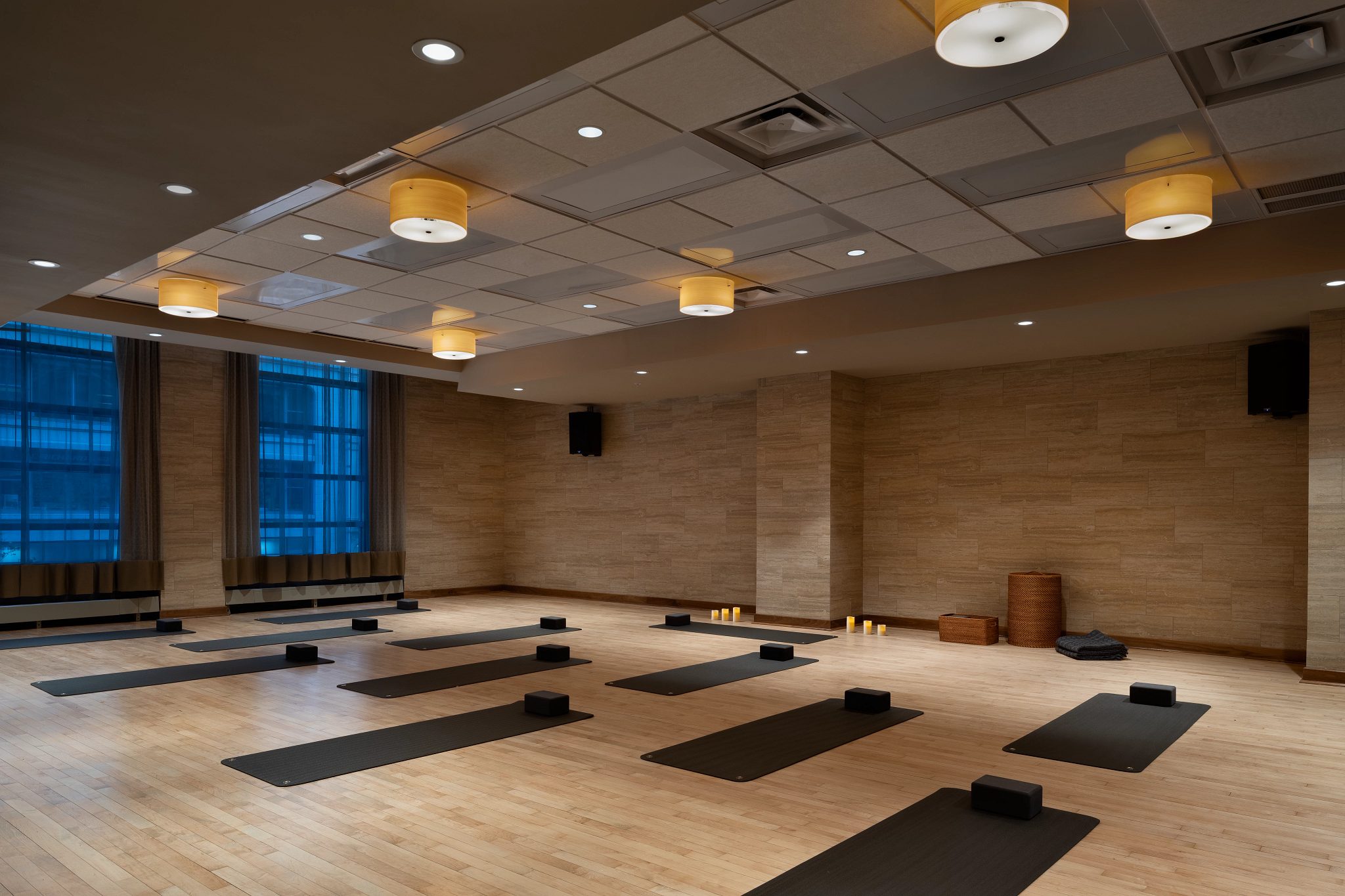 A warmly lit yoga studio with yoga mats