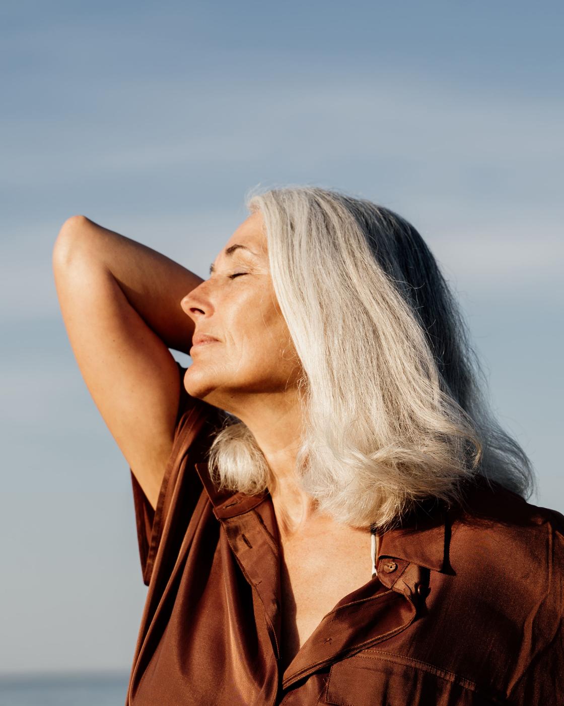 woman looking into the sunlight with a smile on her face