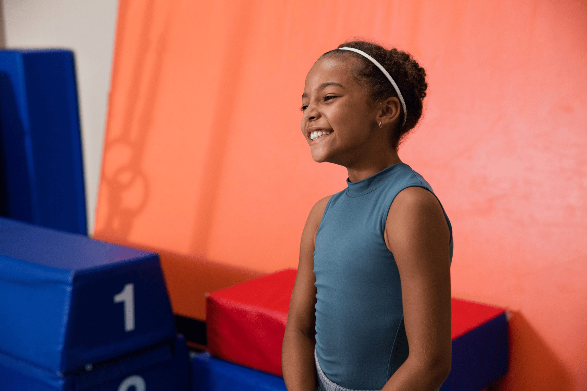 young girl smiling wearing a white headband