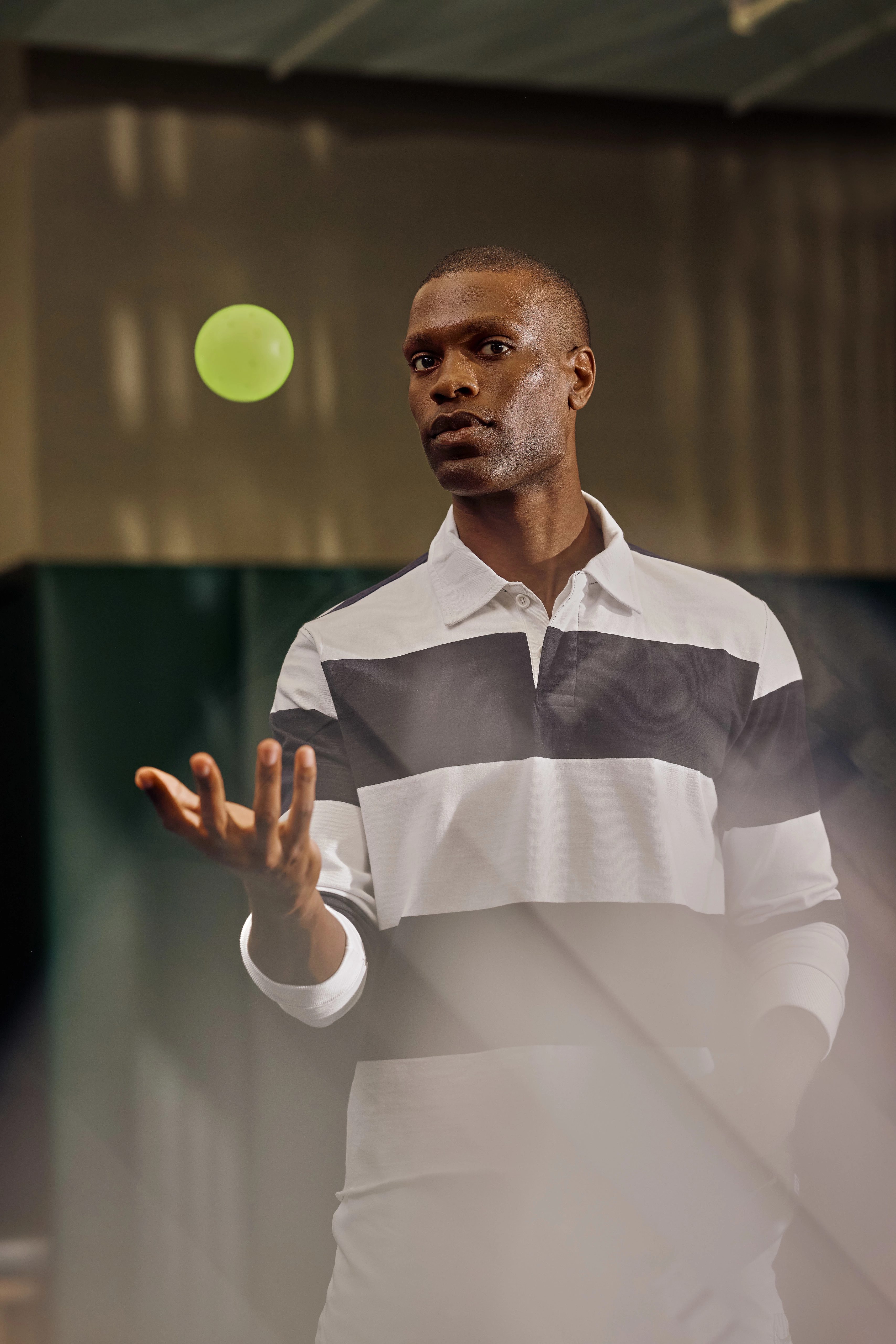 a man tossing a pickleball in the air