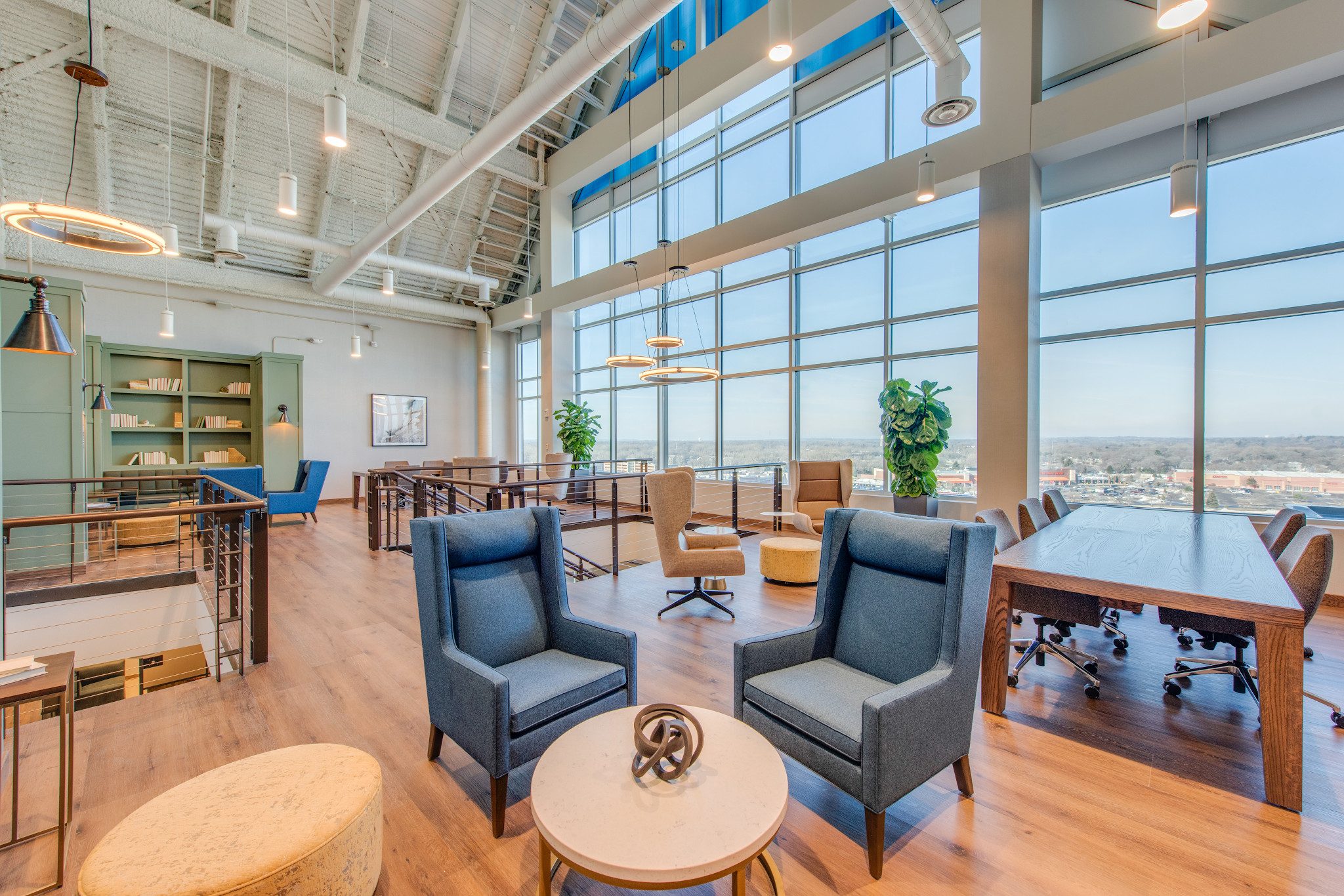 Ample seating areas and coworking spaces scattered around a coworking area, with floor to ceiling windows