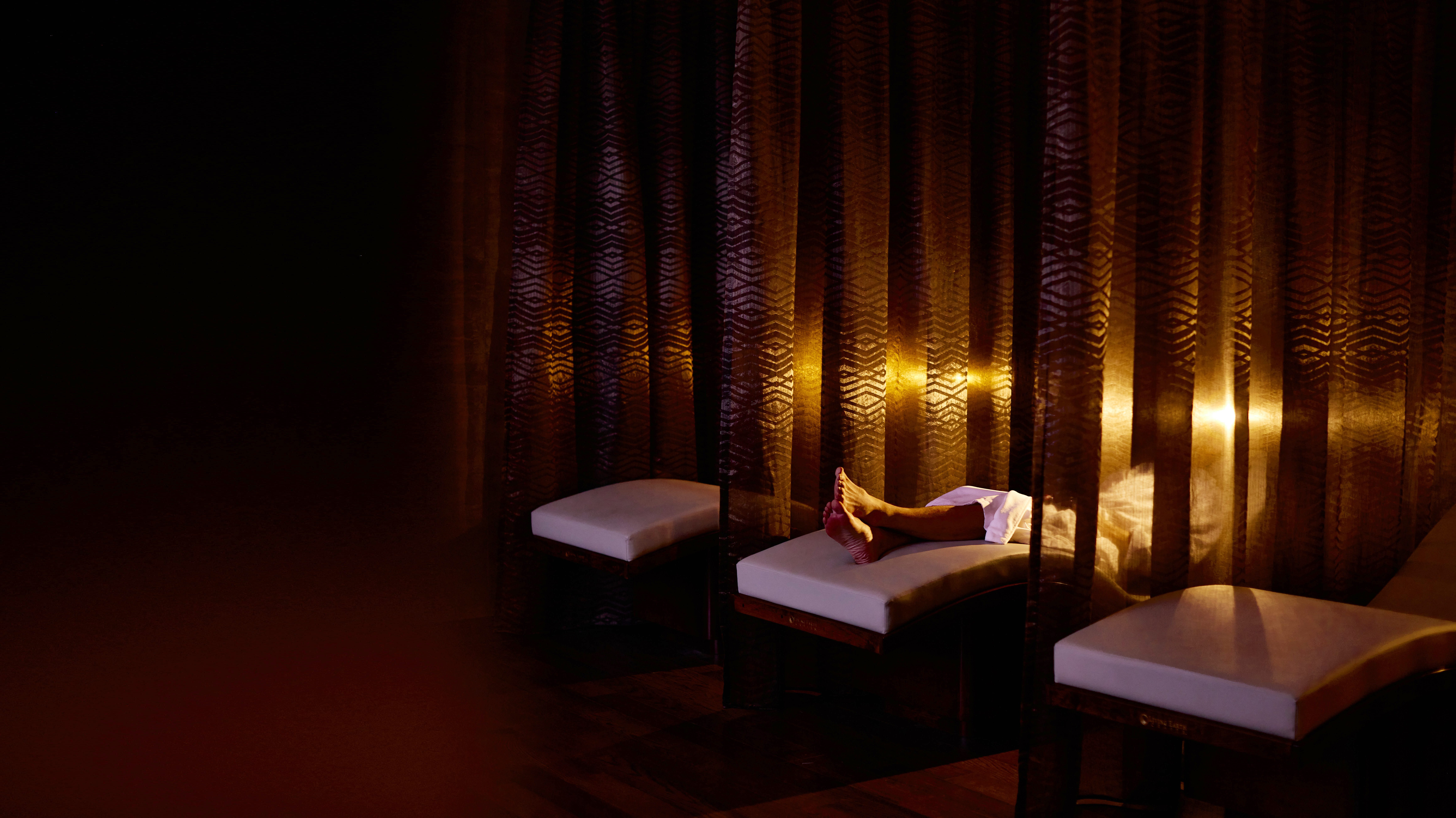 A man relaxing in a white bathrobe and laying in a lounge chair