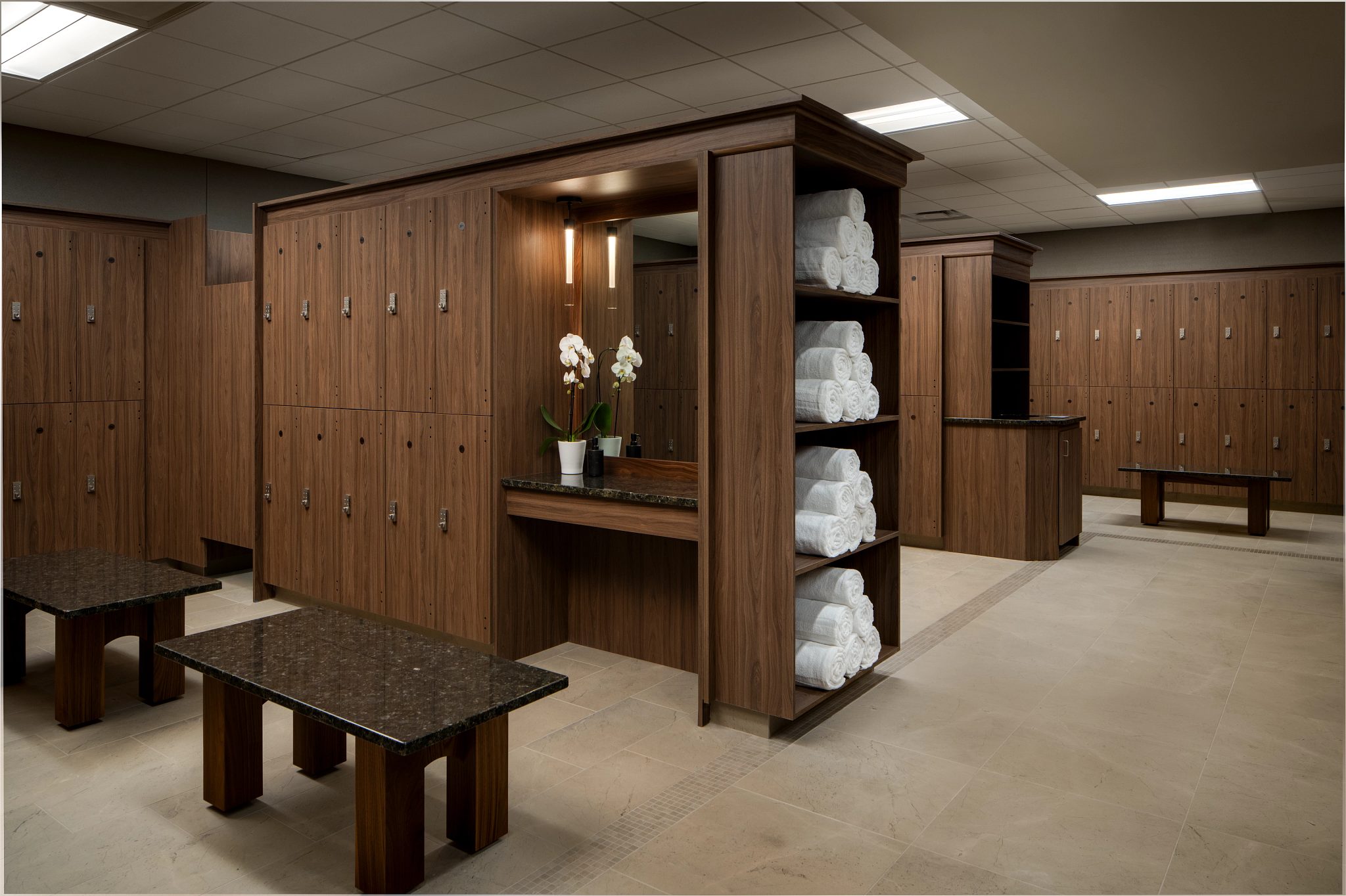 Locker bays with rolled white towels in the locker room at Life Time