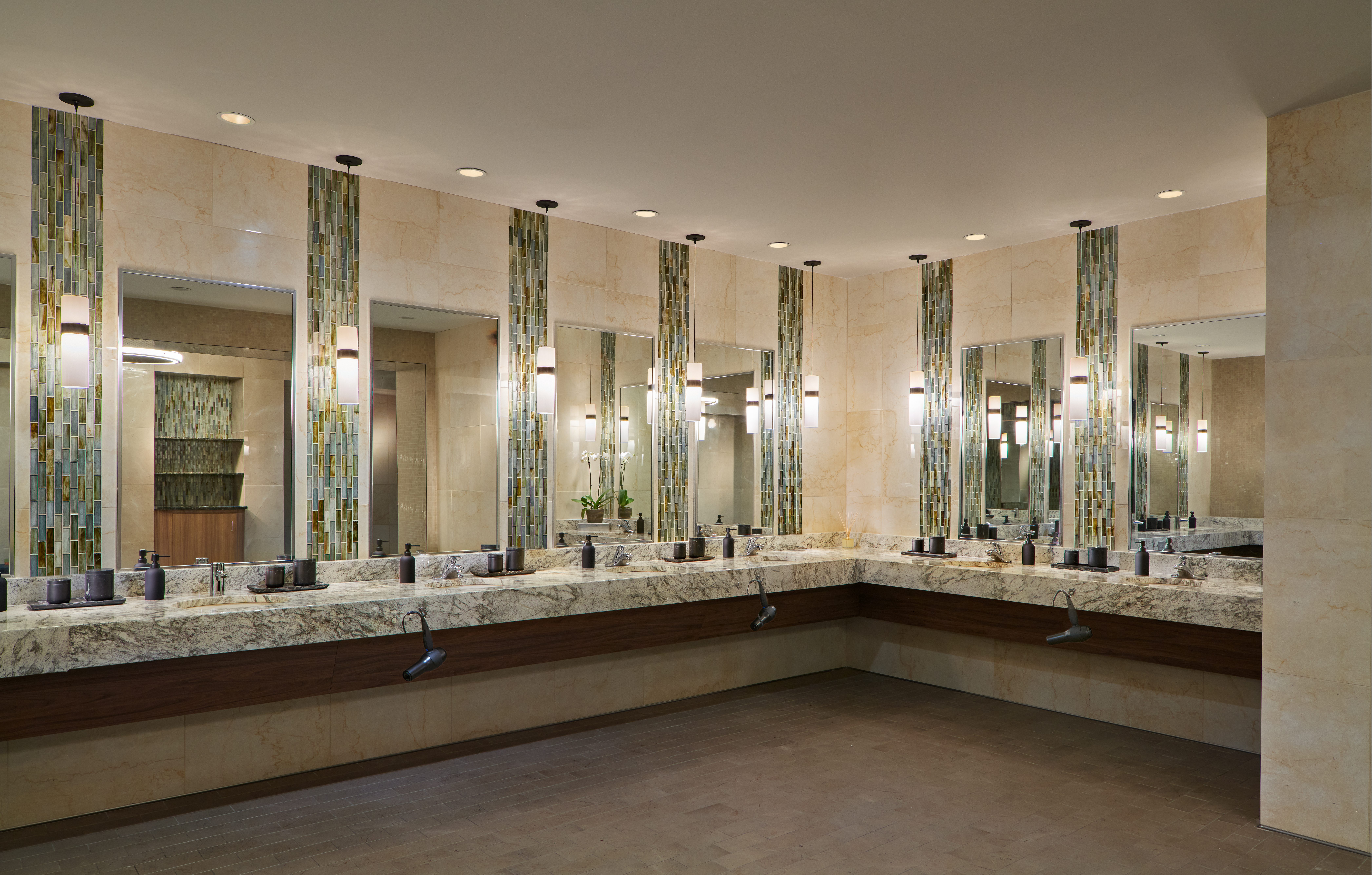 marble tile and glass sink area, with large mirrors