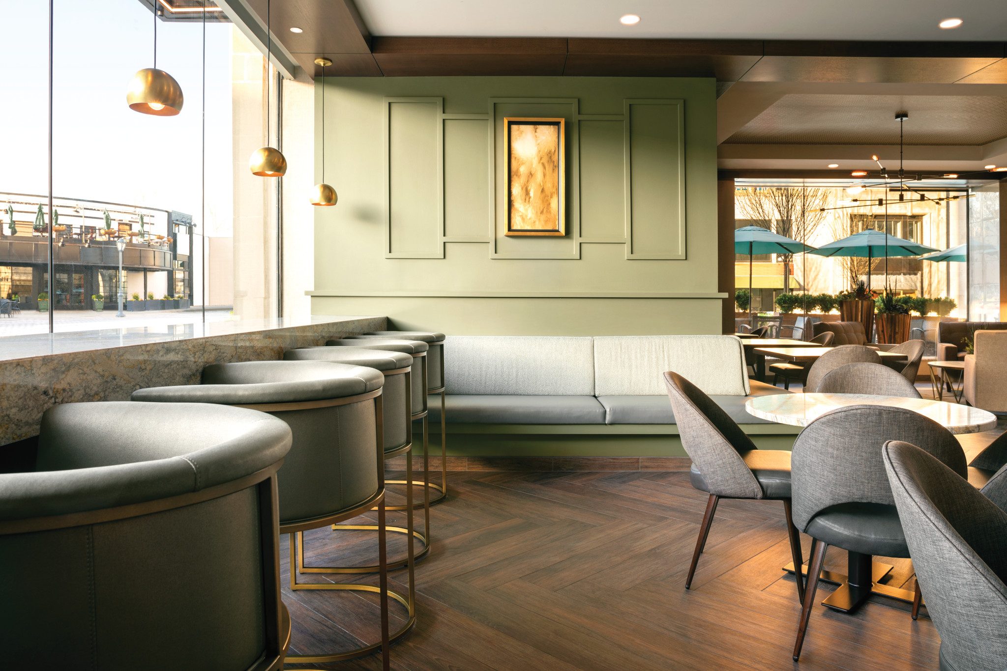 A trendy workspace with cushioned chairs, tables and hanging lights at Life Time Work Ardmore