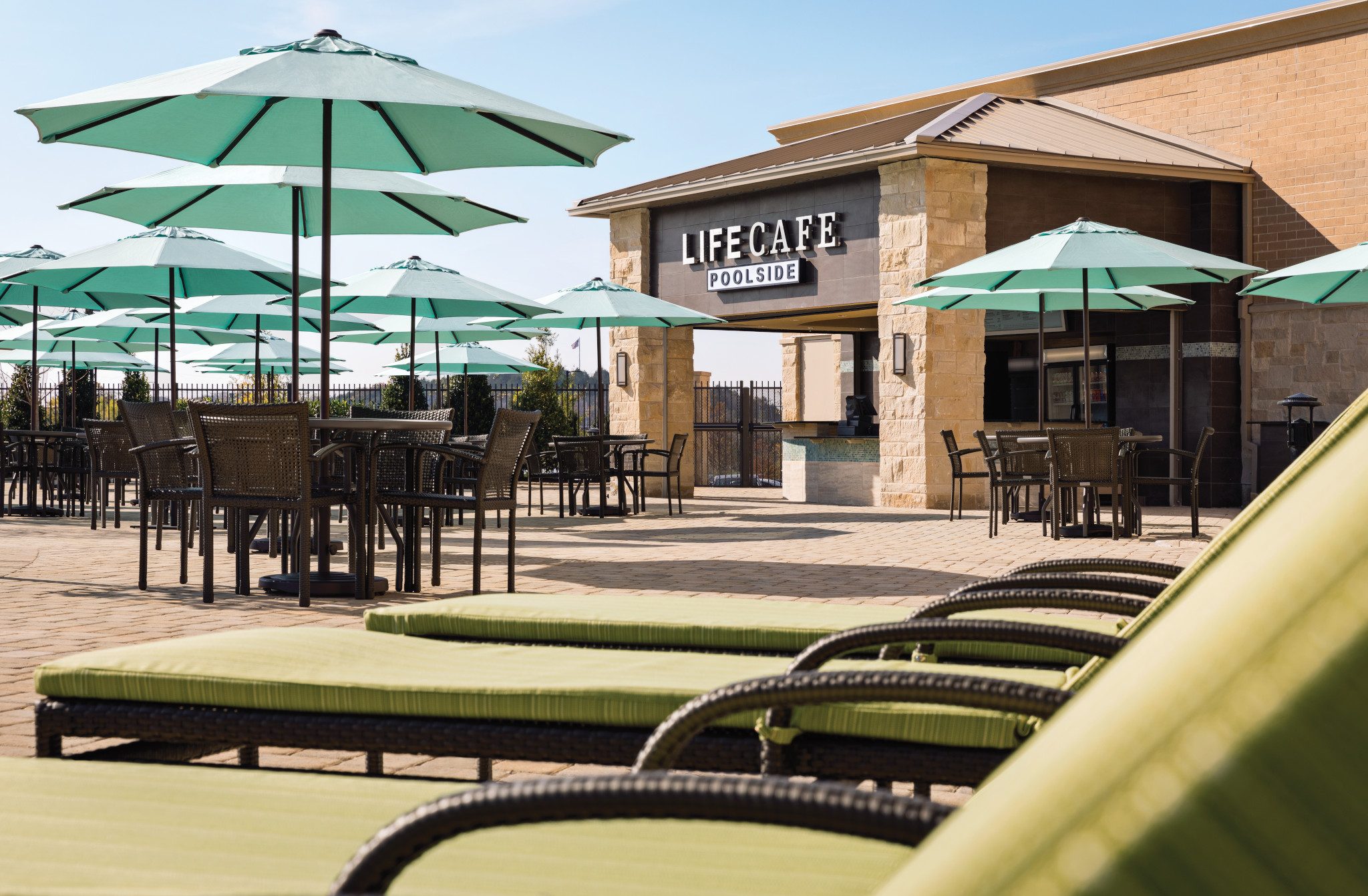 Tables, chairs, and umbrellas next to an outdoor pool