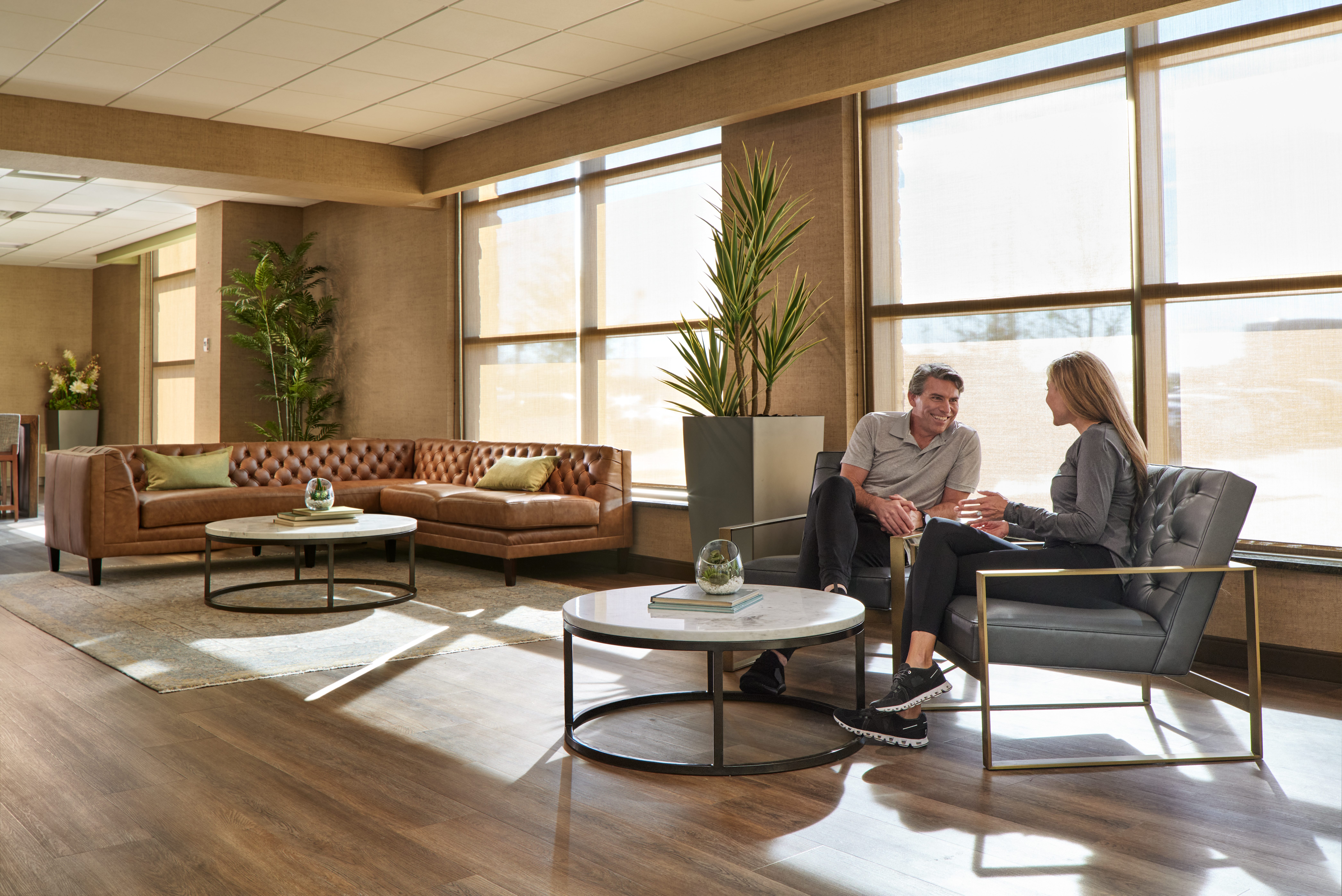 a man and a woman share conversation in a cozy lounge area