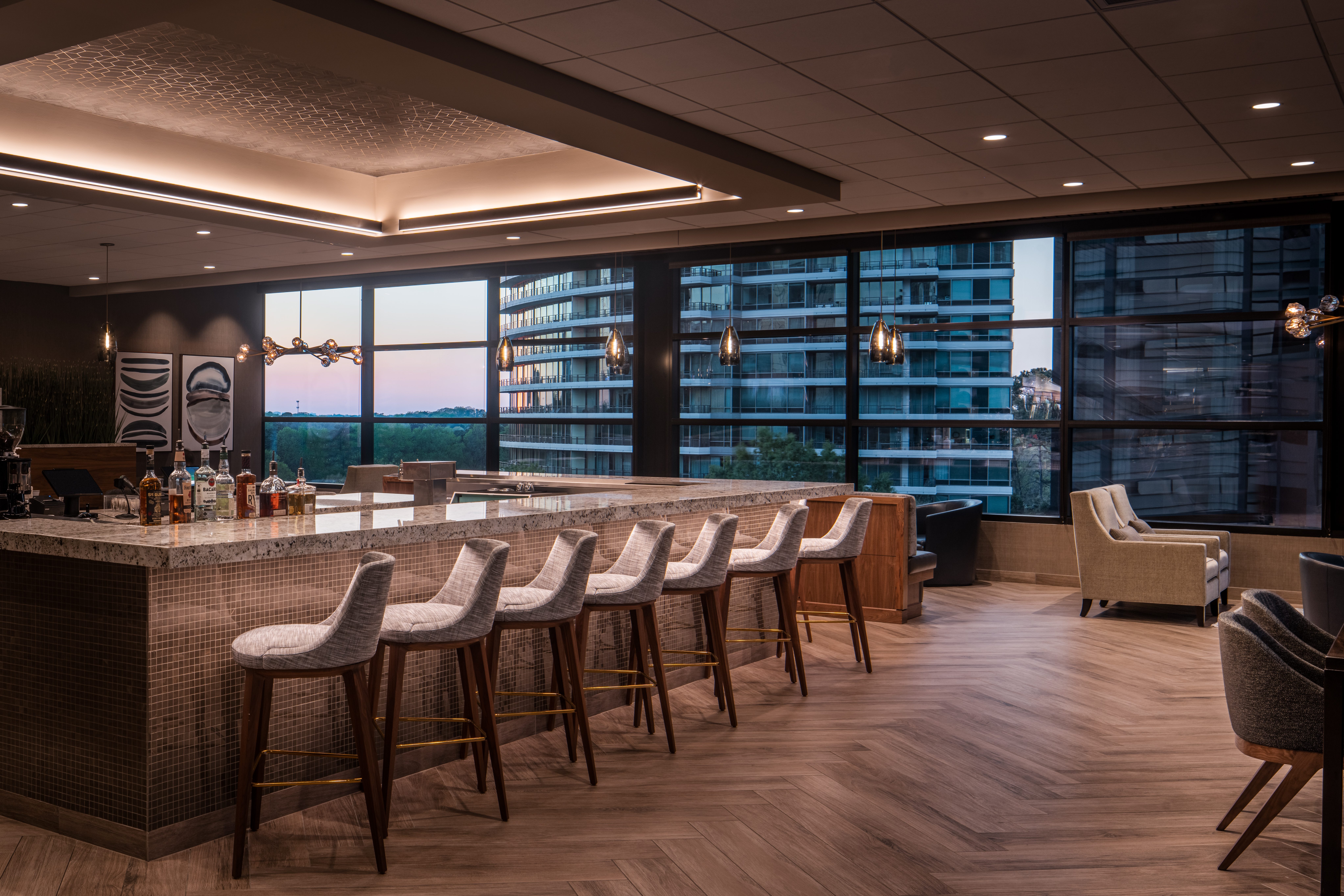 A bar with seating and lounge chairs and tables
