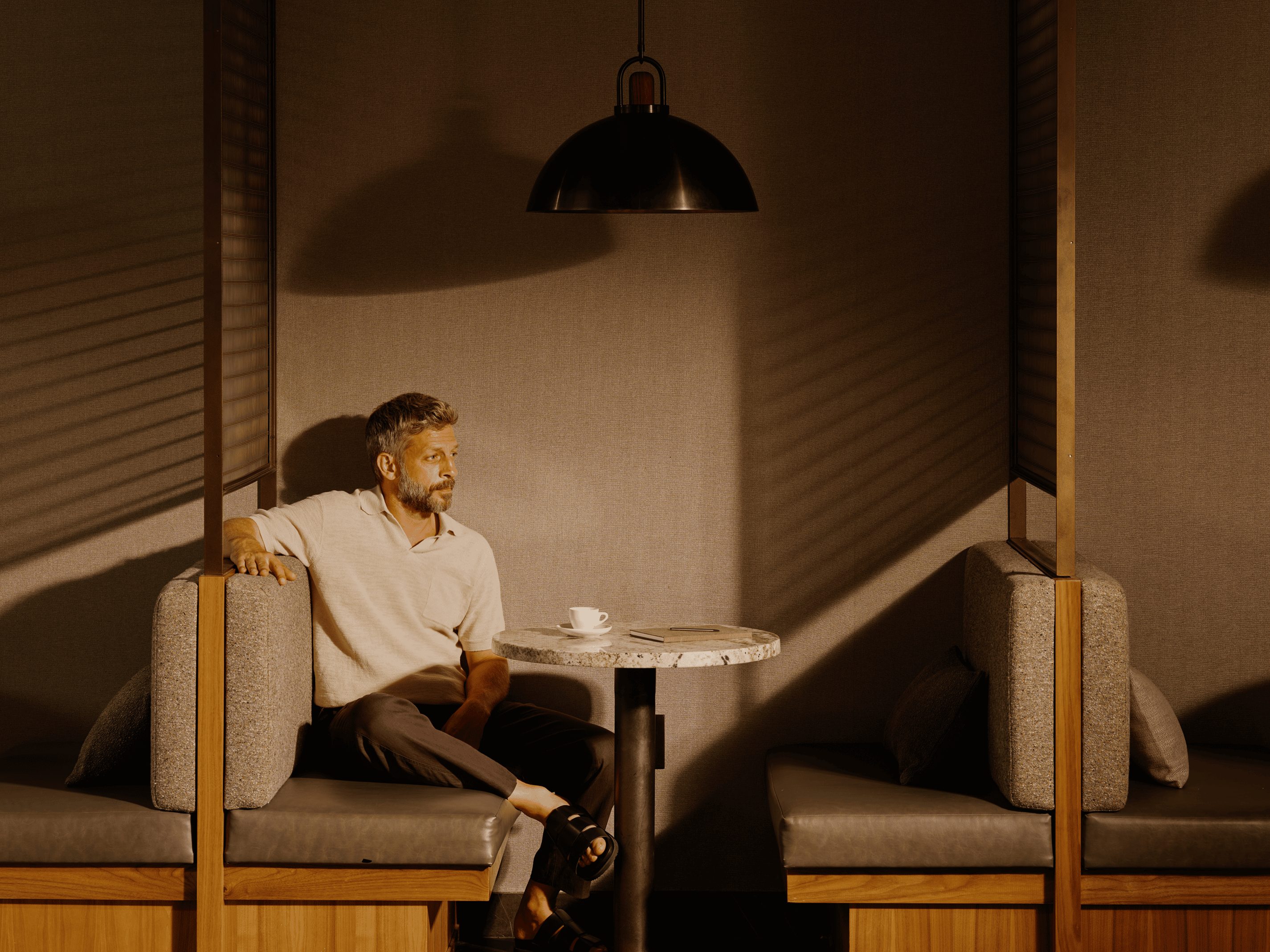 A man sitting in a booth with a coffee