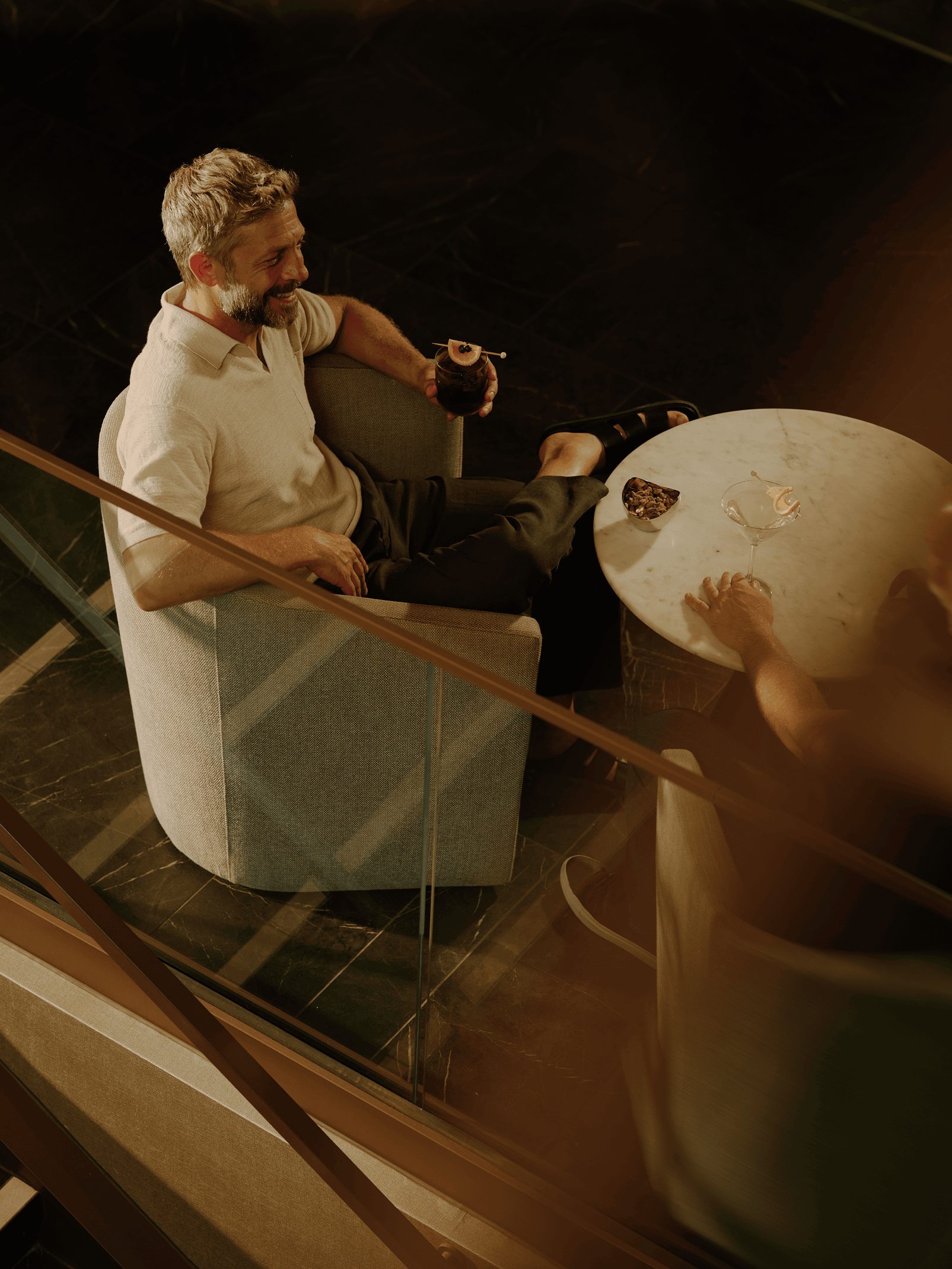 a man sitting down with a drink at the lounge