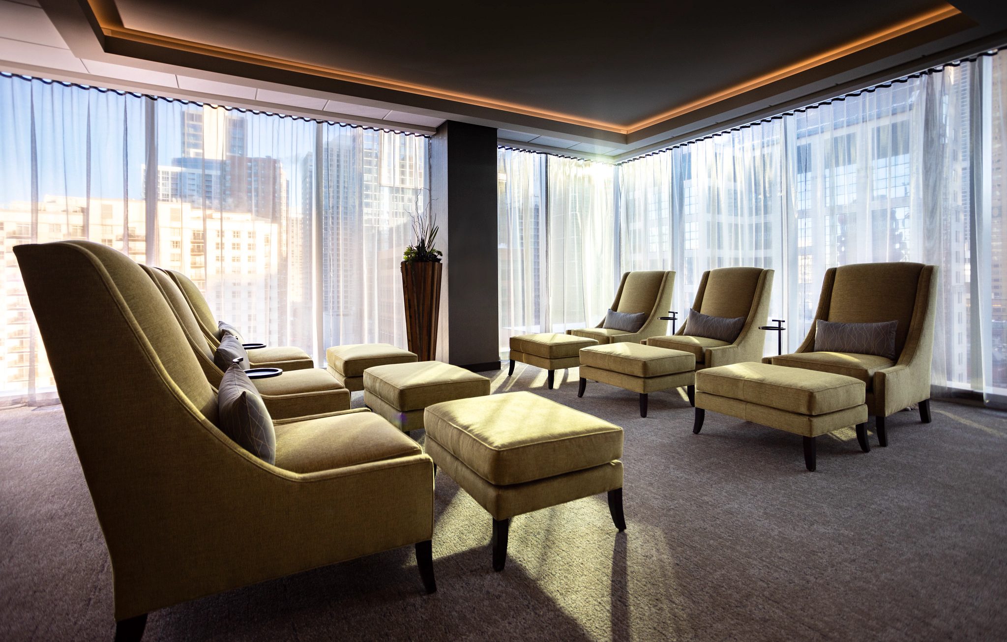 Cozy chairs in a seating area surrounded by floor to ceiling windows