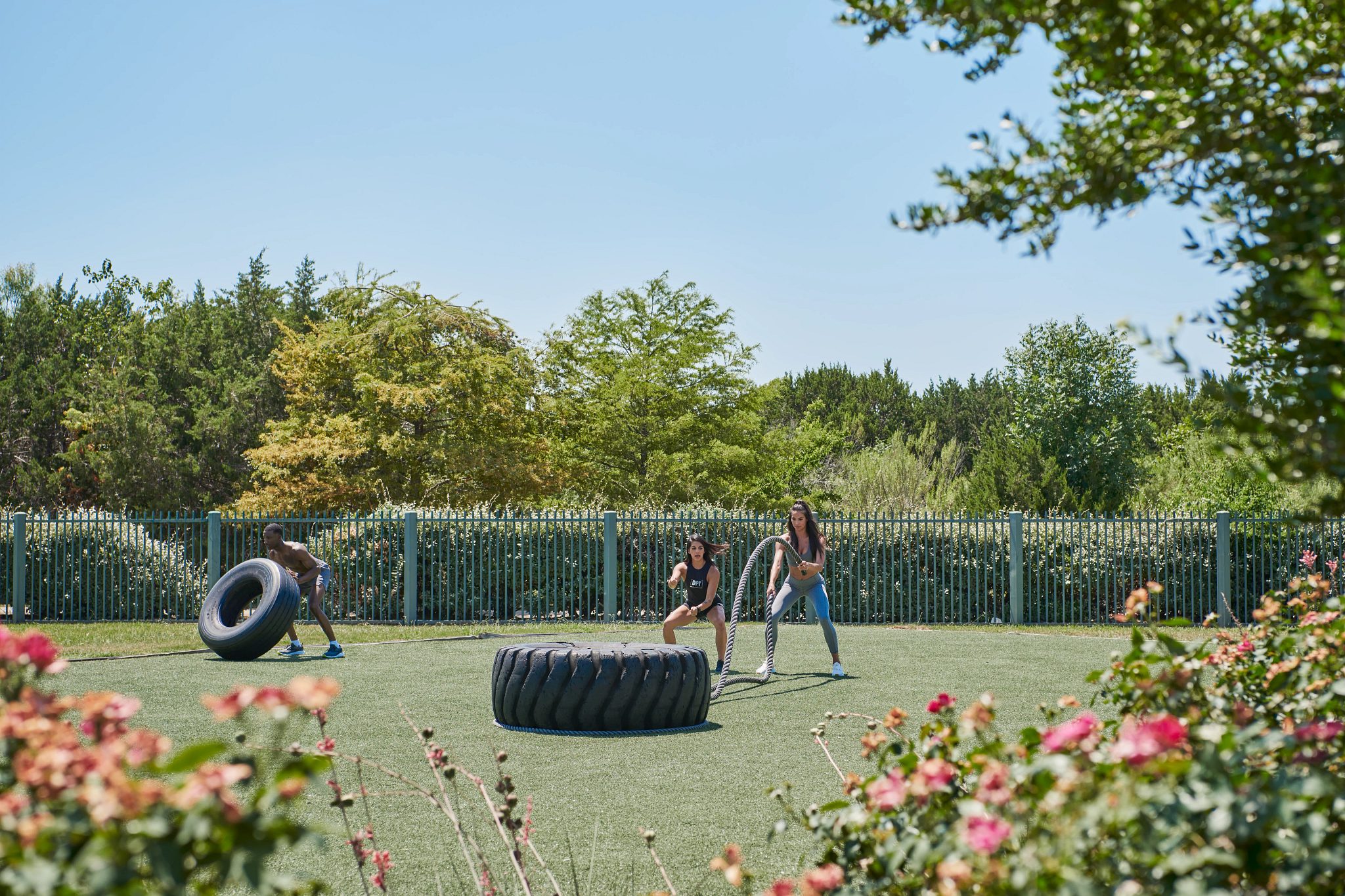 A female dynamic personal trainer showing a member how to properly train with weighted ropes