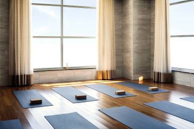 Photograph taken at our Folsom, California club location., Naturally lit yoga studio with two large windows and blue mats spaced out evenly on hard wood floor with cork block sitting on the mats.
