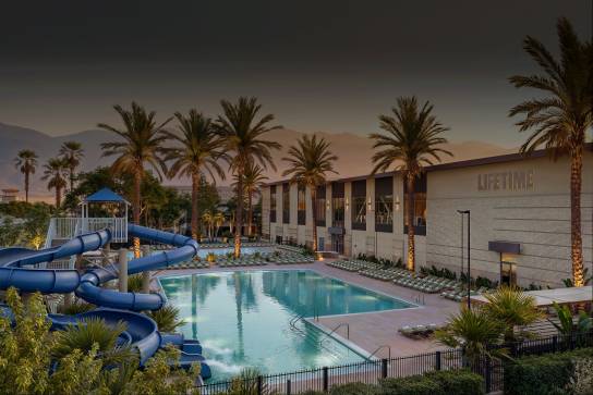 outdoor pool with lounge chairs and waterslide