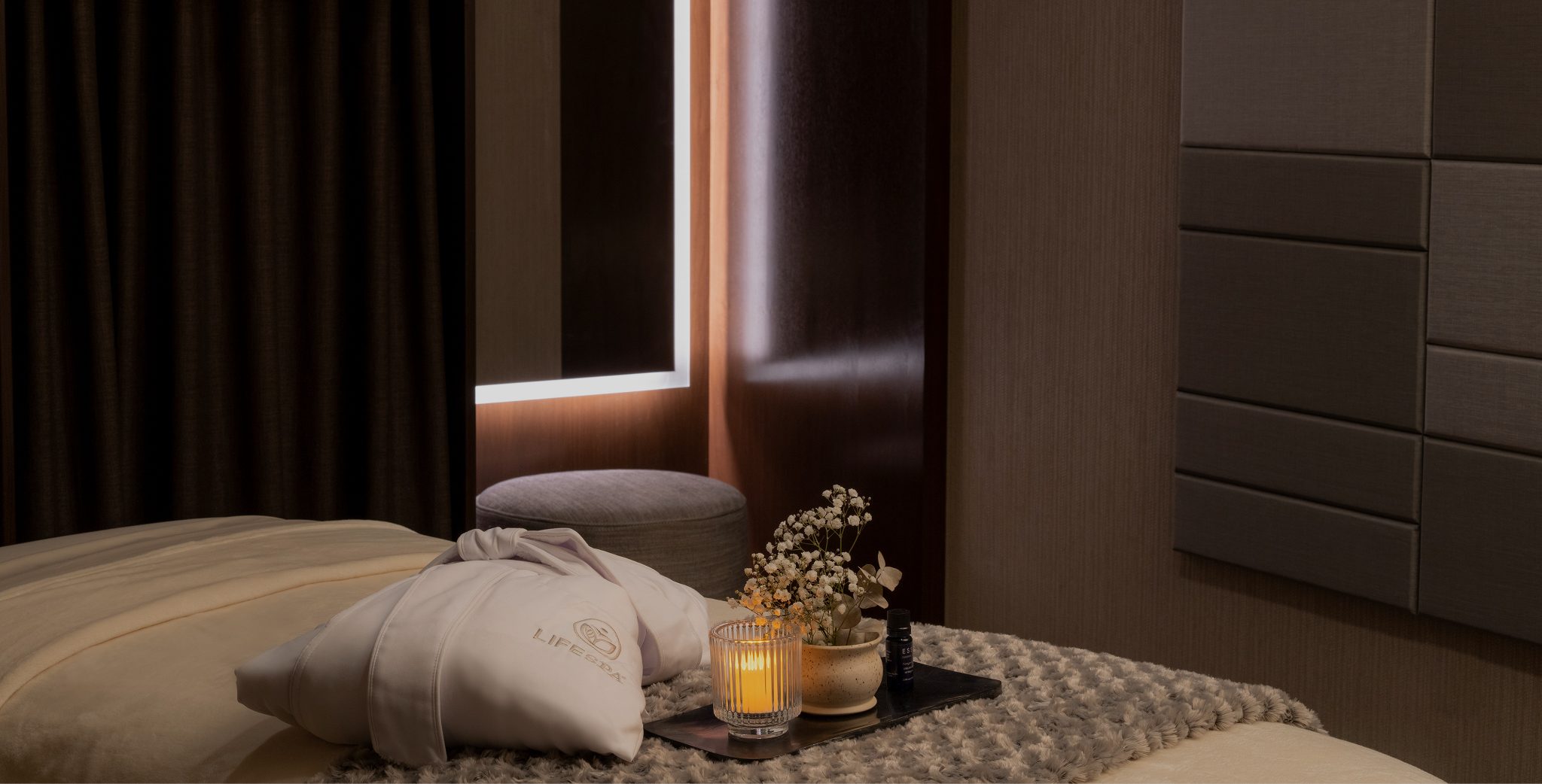 spa robe on a massage table with a candle