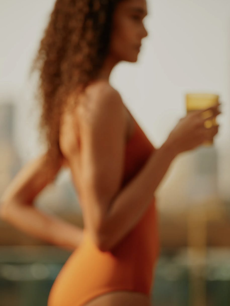 woman wearing a red swimsuit holding a glass 