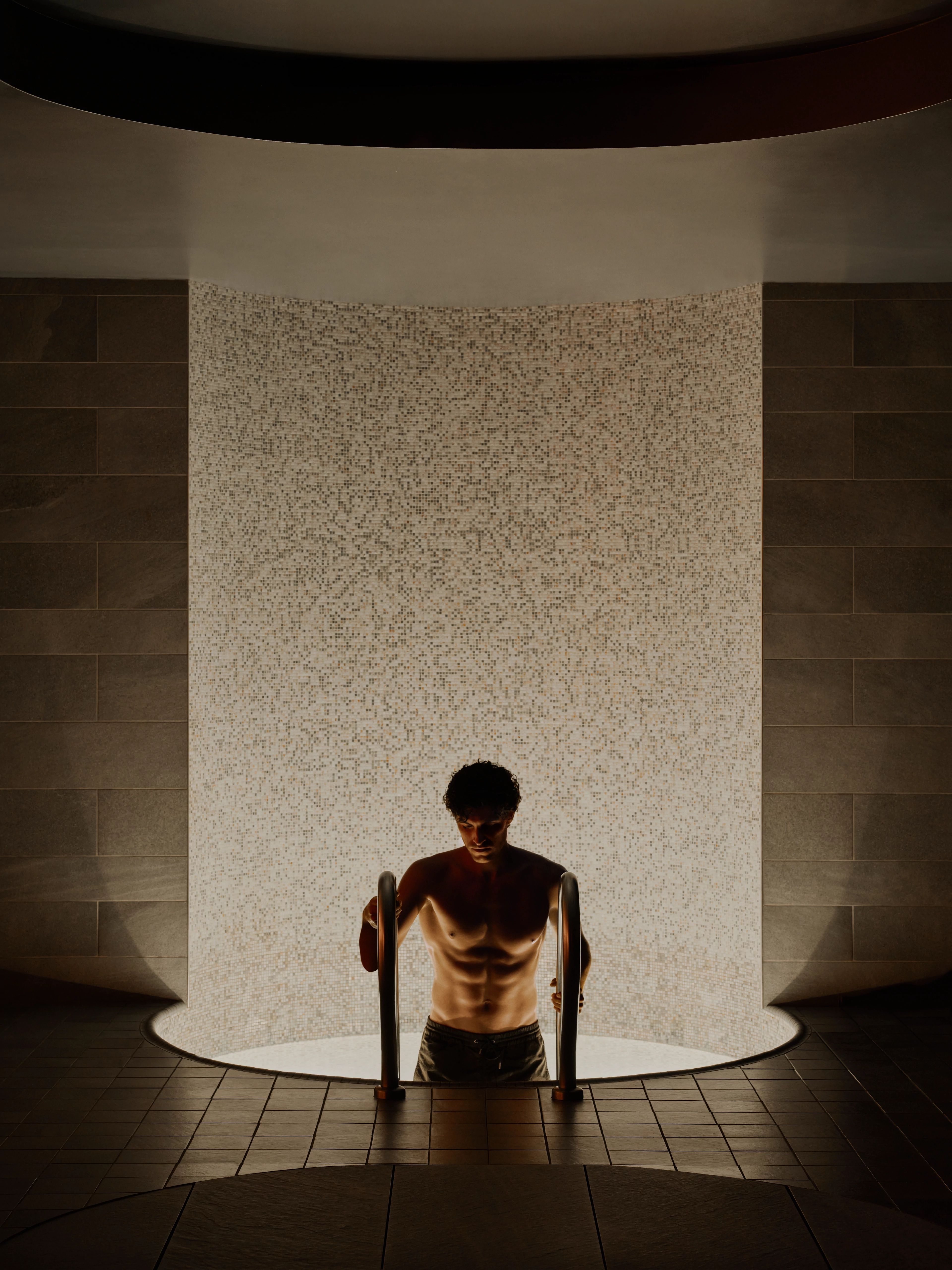 man climbing out of a cold plunge