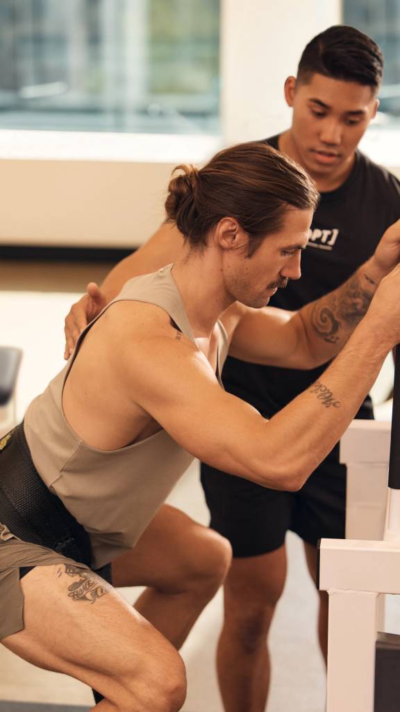 man squatting with a waist belt on