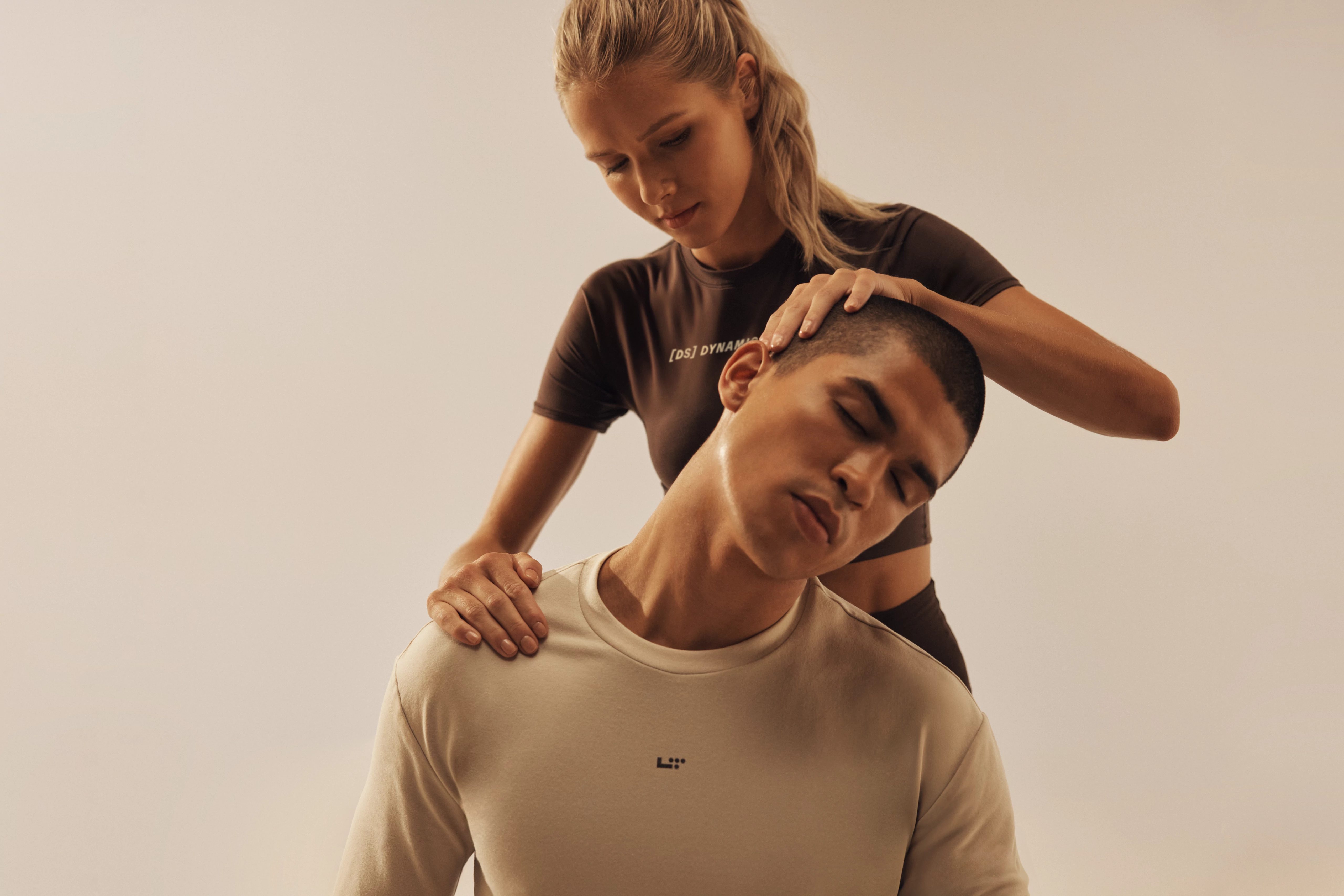 instructor helping a member stretch out his neck