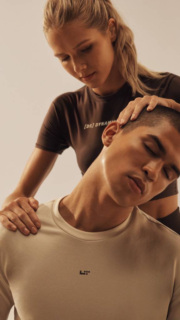 instructor helping a member stretch out his neck