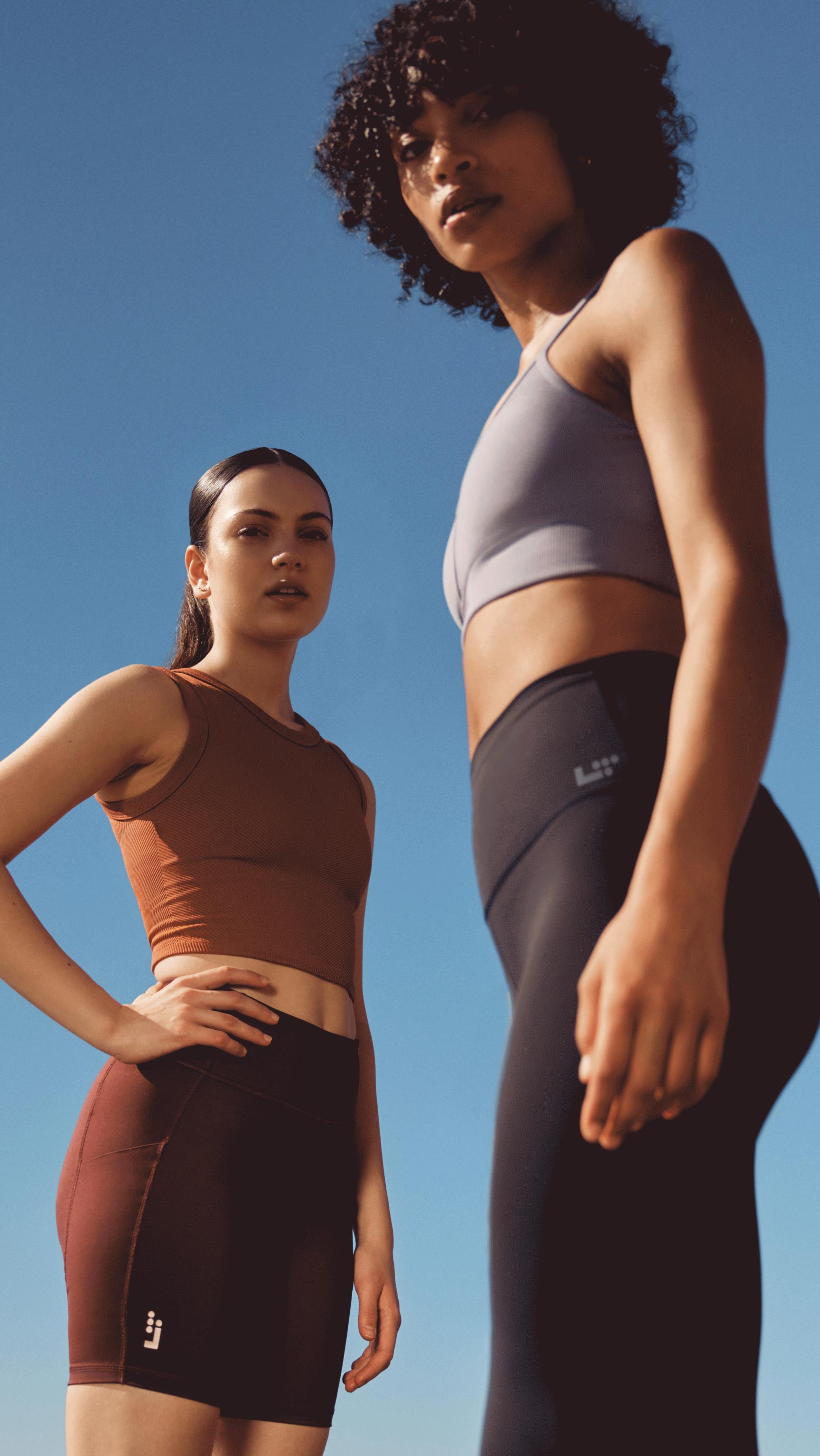 two women standing outside in workout clothes