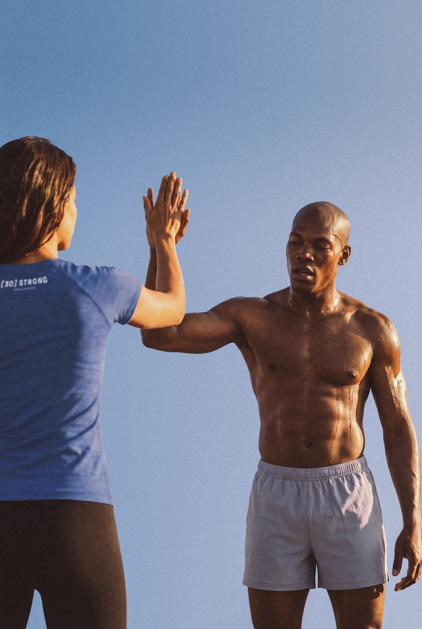 A 30 Strong Dynamic Personal trainer giving a high-five in celebration with her client