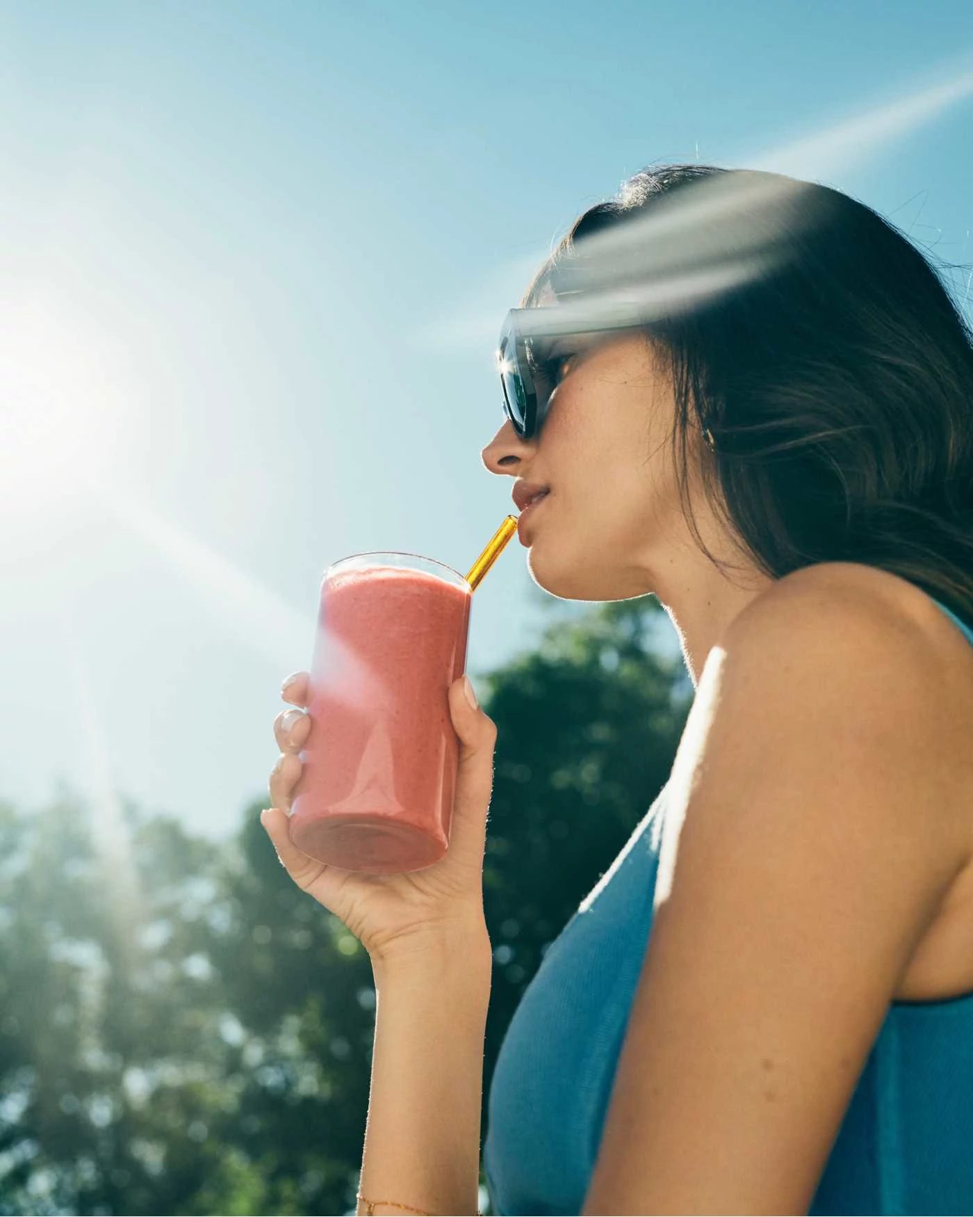 woman drinking a smoothie outside