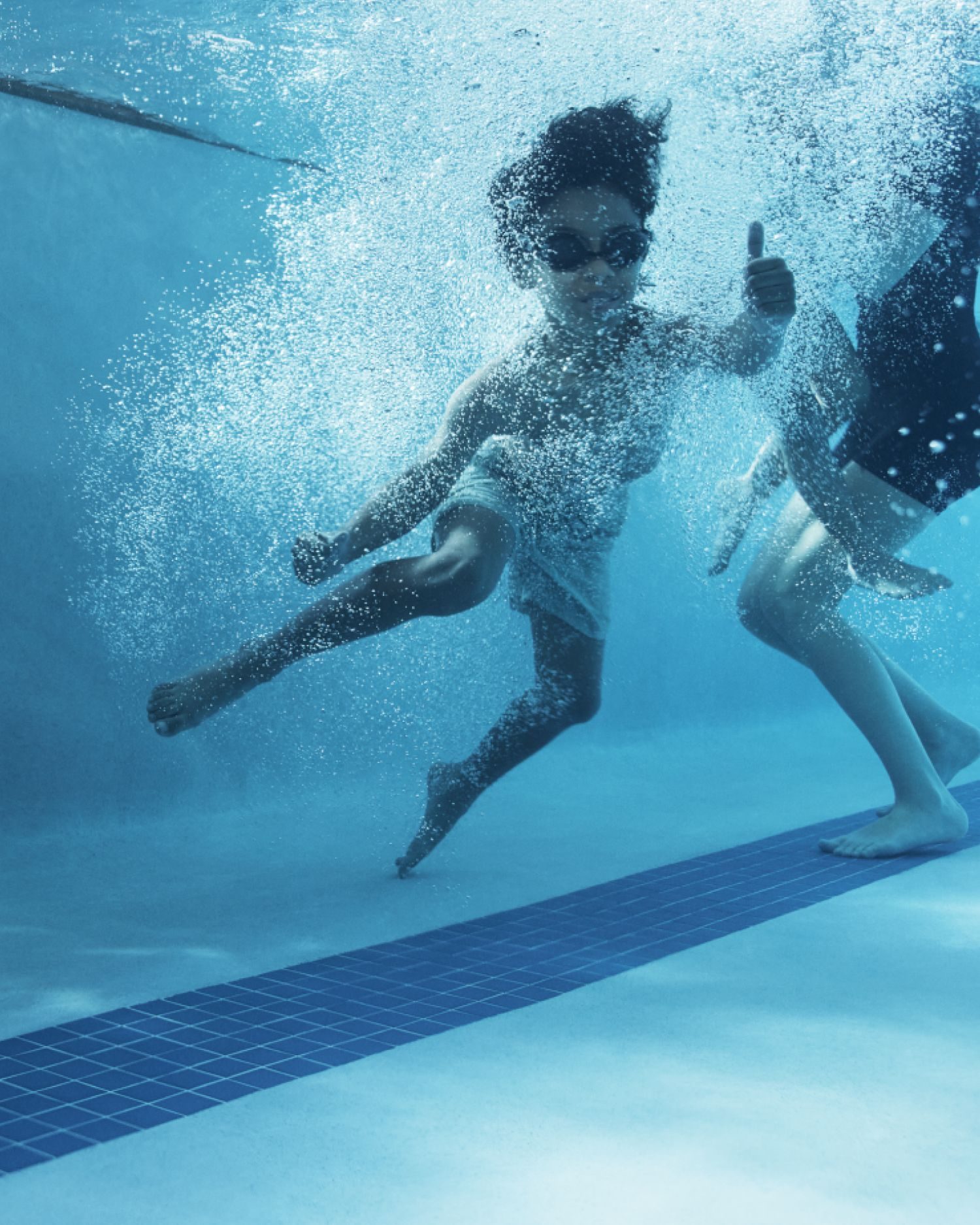 a kid jumping into a swimming pool