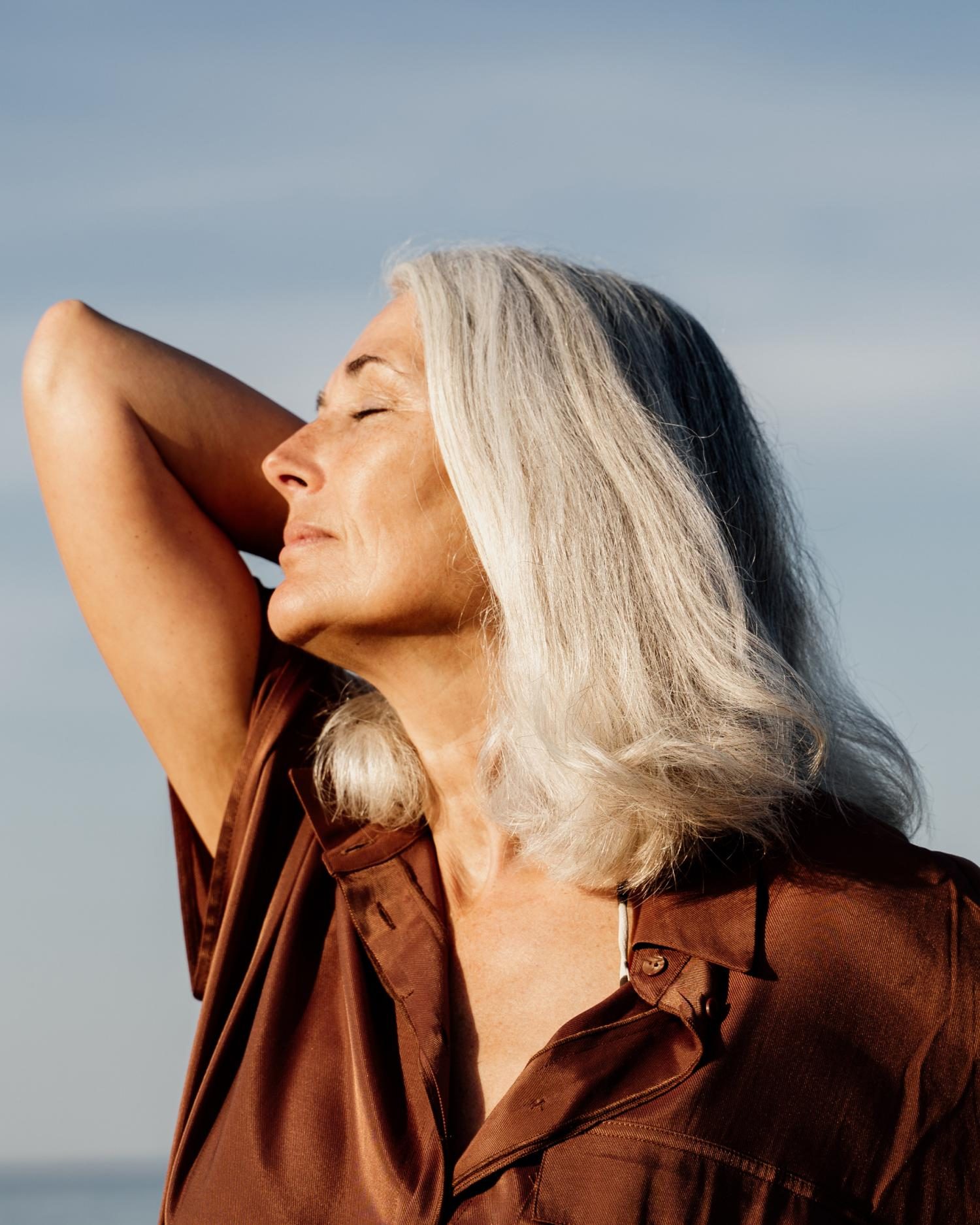 a woman stretching towards the sun