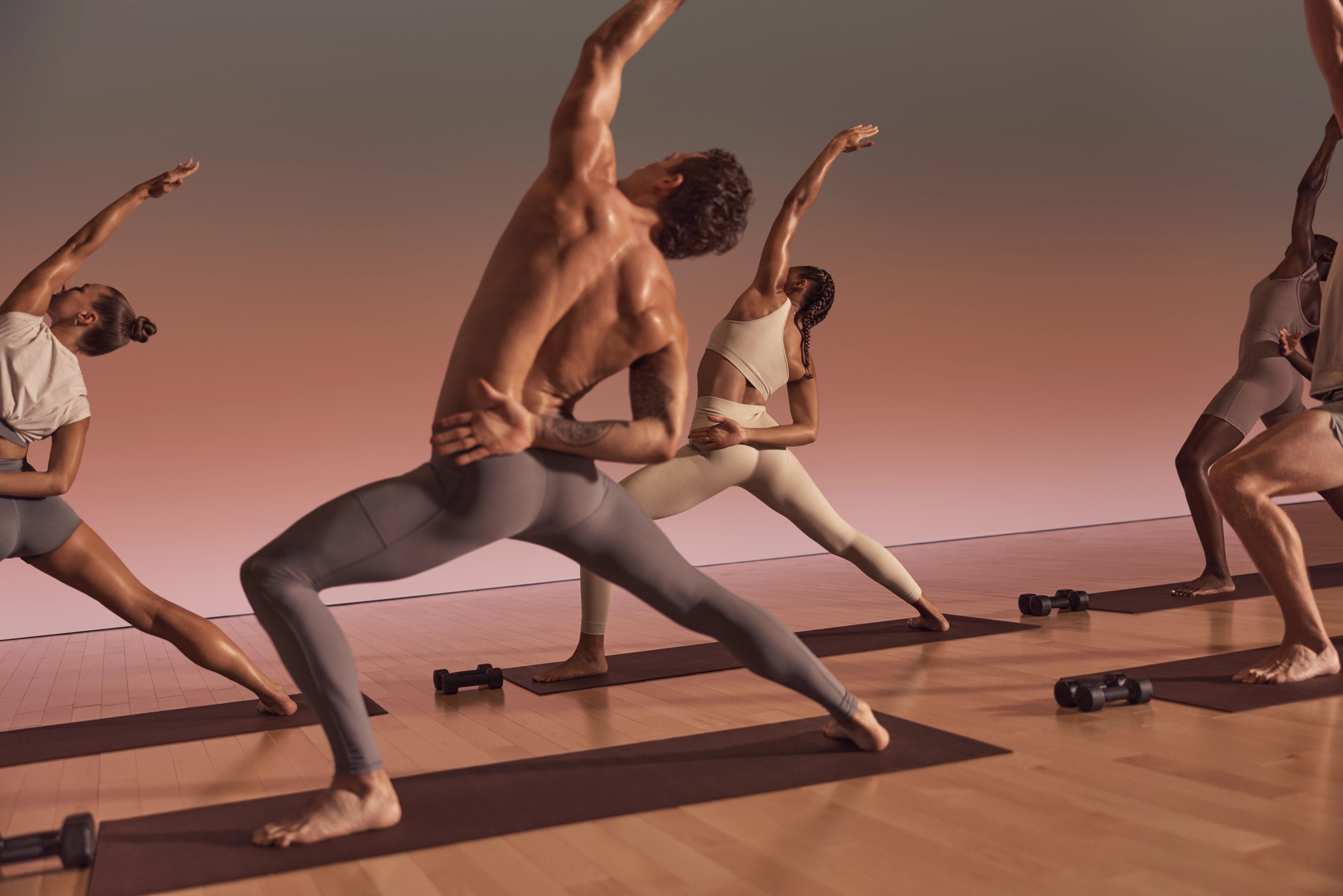 Warrior sculpt class participants in a side opener variation of a warrior pose