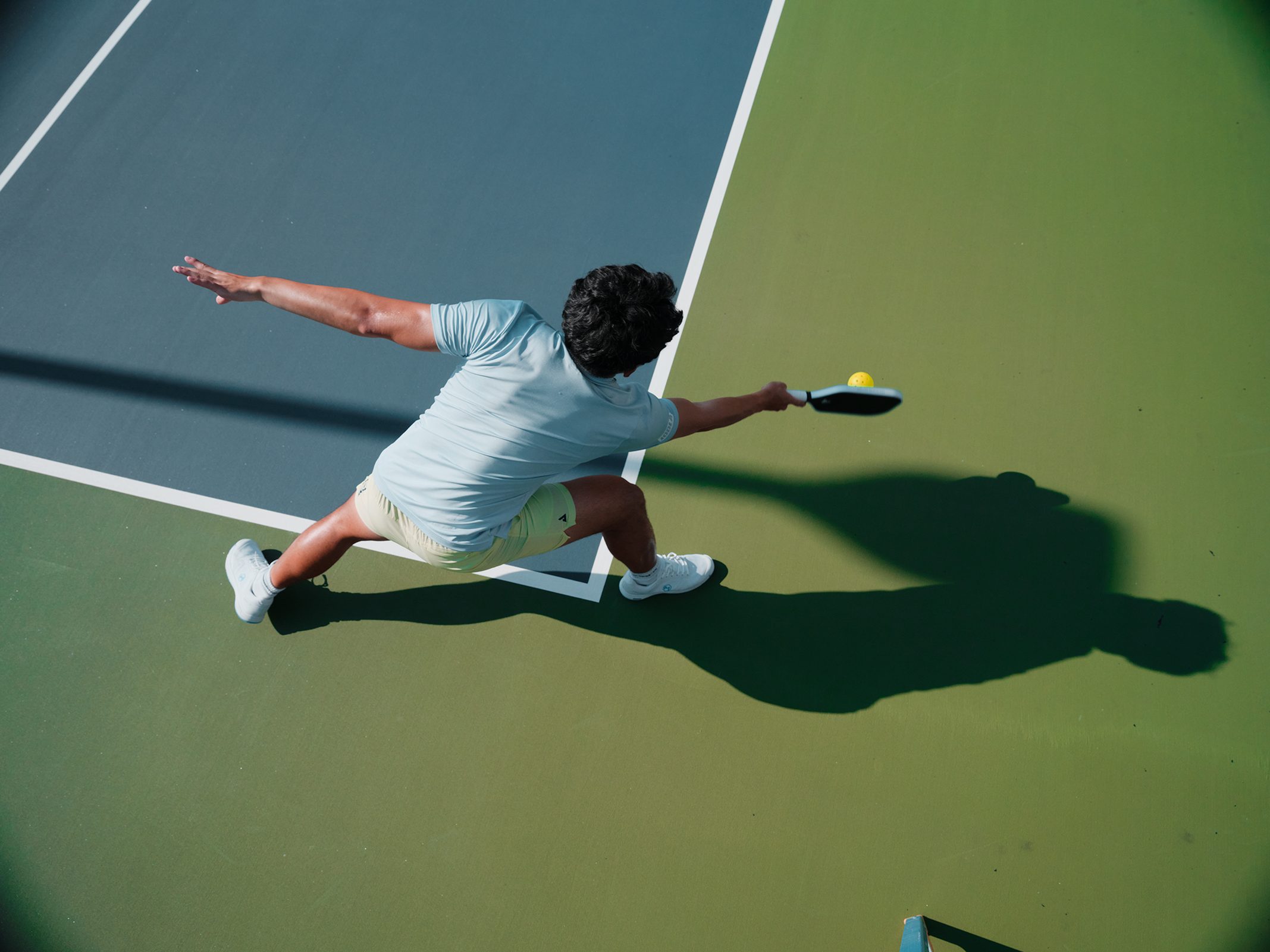 man hitting a pickleball with a paddle